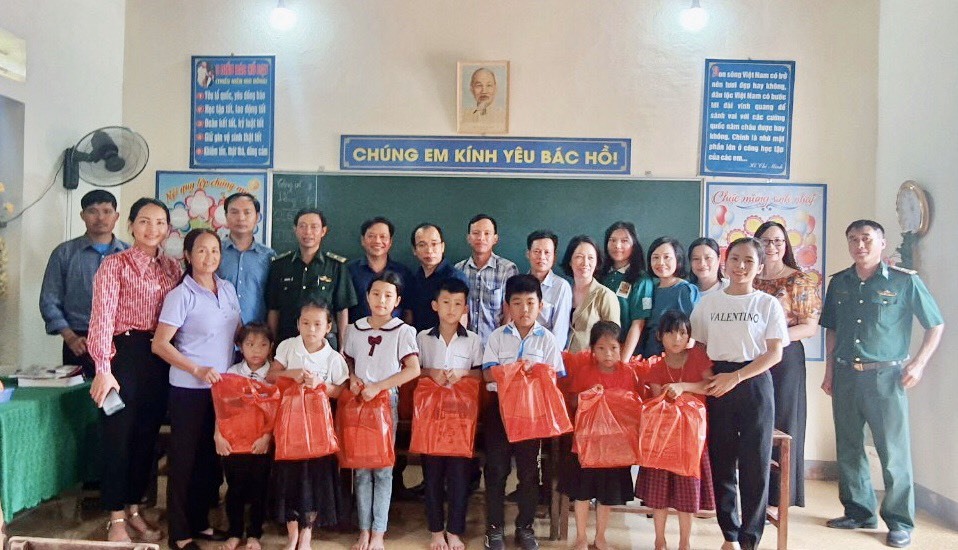Các mạnh thường quân trao tặng SGK và vở viết cho các em học sinh tại điểm trường Phú Lâm - Hương Khê. Ảnh La Giang