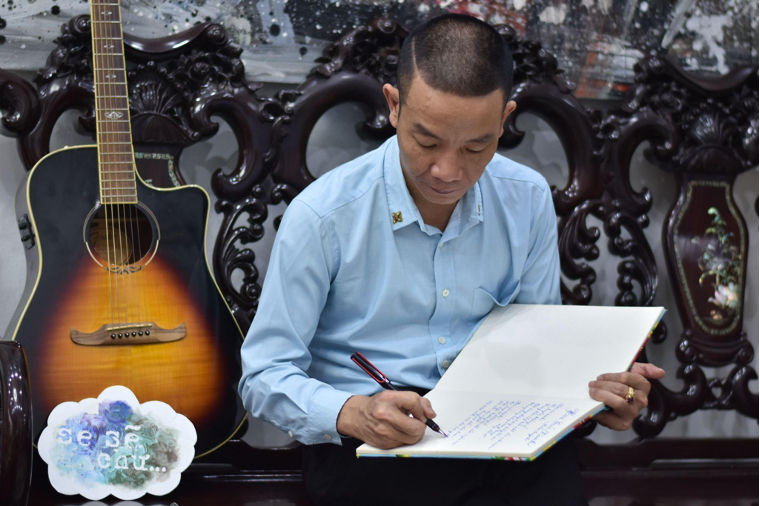 Nhạc sĩ Nguyễn Vĩnh Tiến chép bài thơ “Hoa cúc xanh” (Ảnh: Hải Anh)