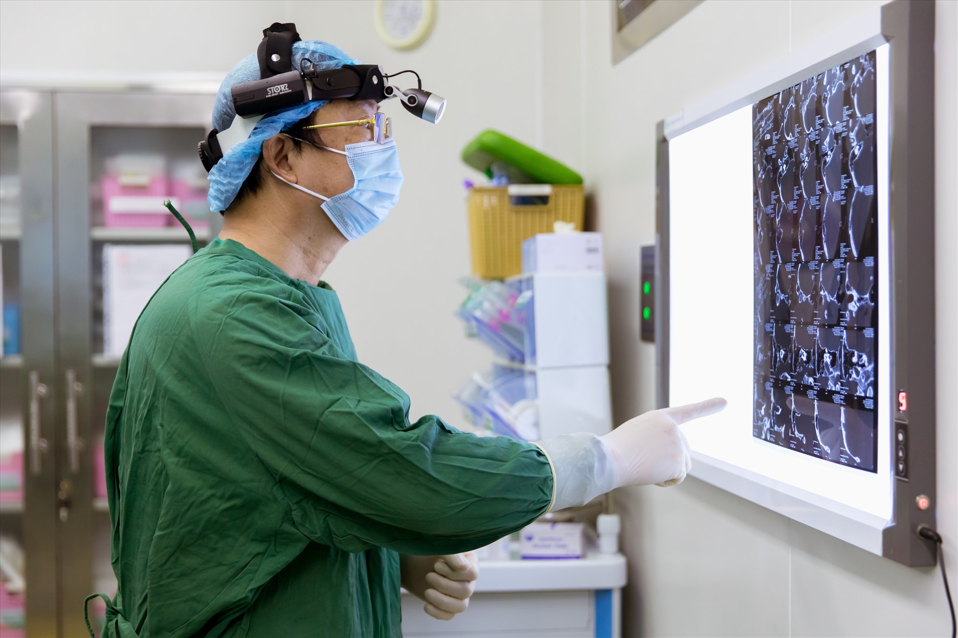 Thầy thuốc ưu tú, bác sĩ Dương Văn Tiến - Trưởng phòng khám tai mũi họng, Bệnh viện ĐKQT Thu Cúc TCI đang xem lại phim chụp của bệnh nhân bị thủng màng nhĩ trước khi bước vào ca phẫu thuật vá nhĩ nội soi.