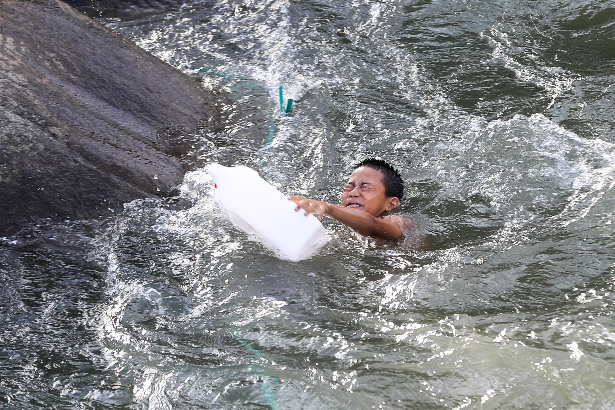 Cậu bé người Thái tập bơi với can nhựa trên dòng suối nước chảy khá mạnh.