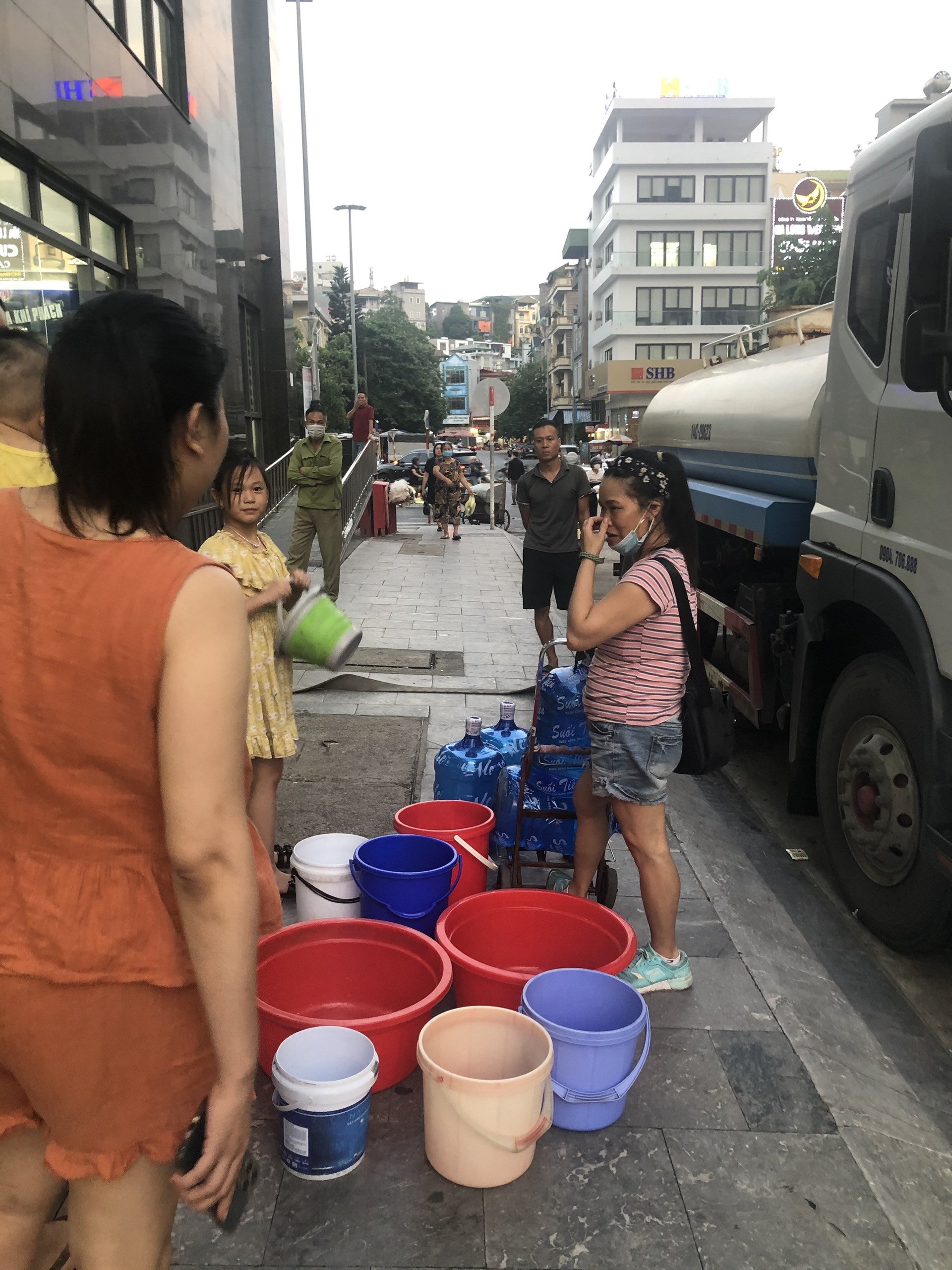 Cư dân chung cư Lideco Hạ Long chờ mua nước từ các xe nước. Ảnh: CTV