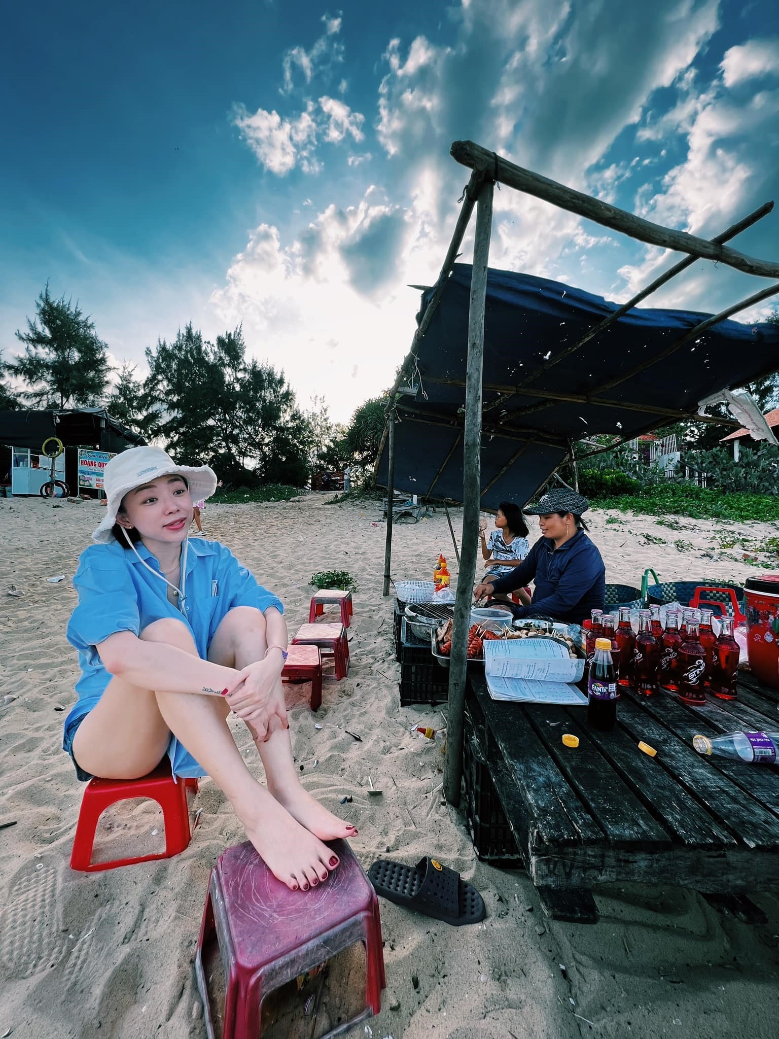 Trước khi ra đầm chụp ảnh, nữ ca sĩ còn nghỉ lại một quán ăn ven đường để thưởng thức món bánh tráng nướng.