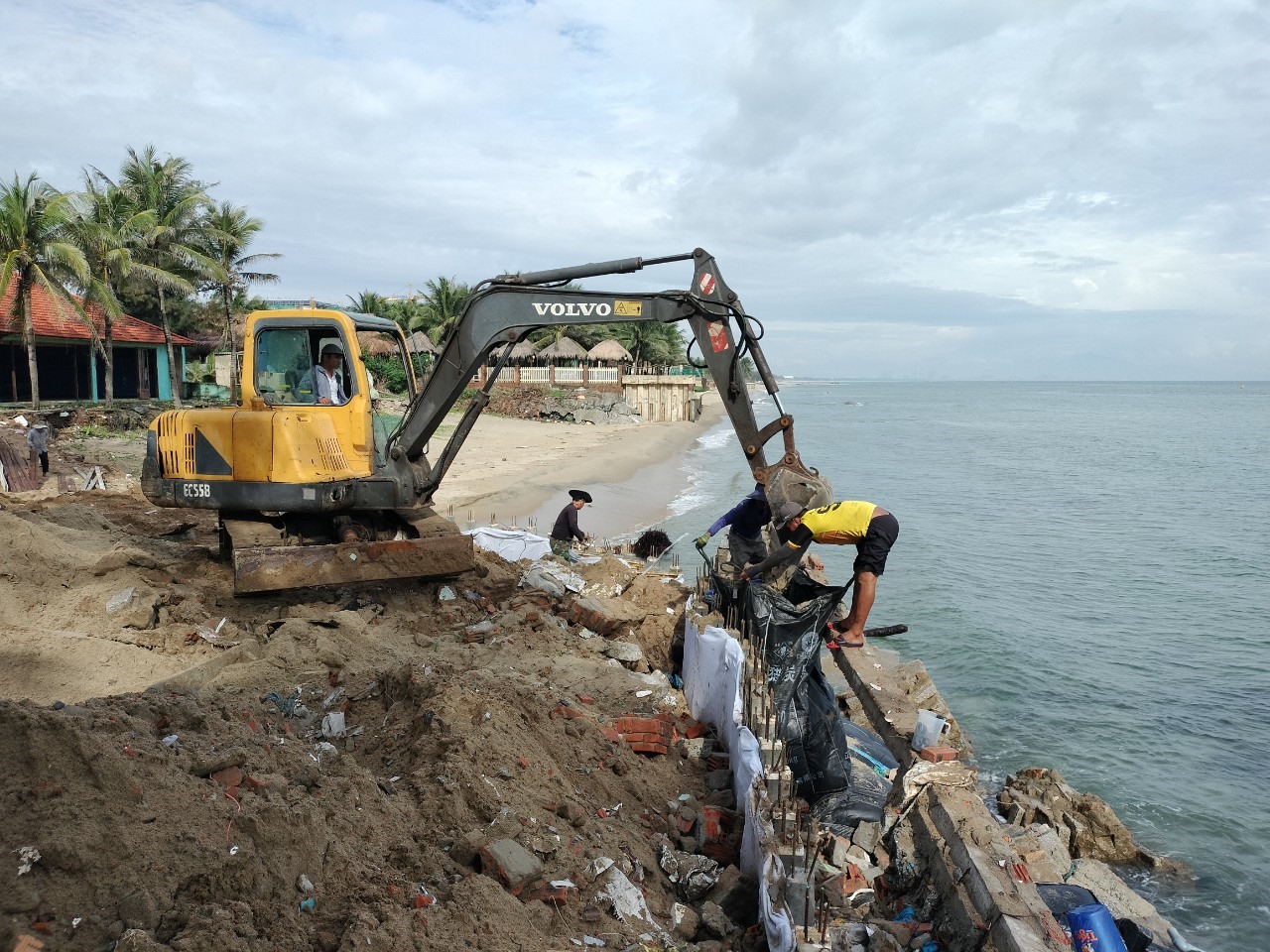 Người dân TP Hội An, tỉnh Quảng Ngãi, huy động máy móc gia cố lại bờ kè biển chống sạt lở.