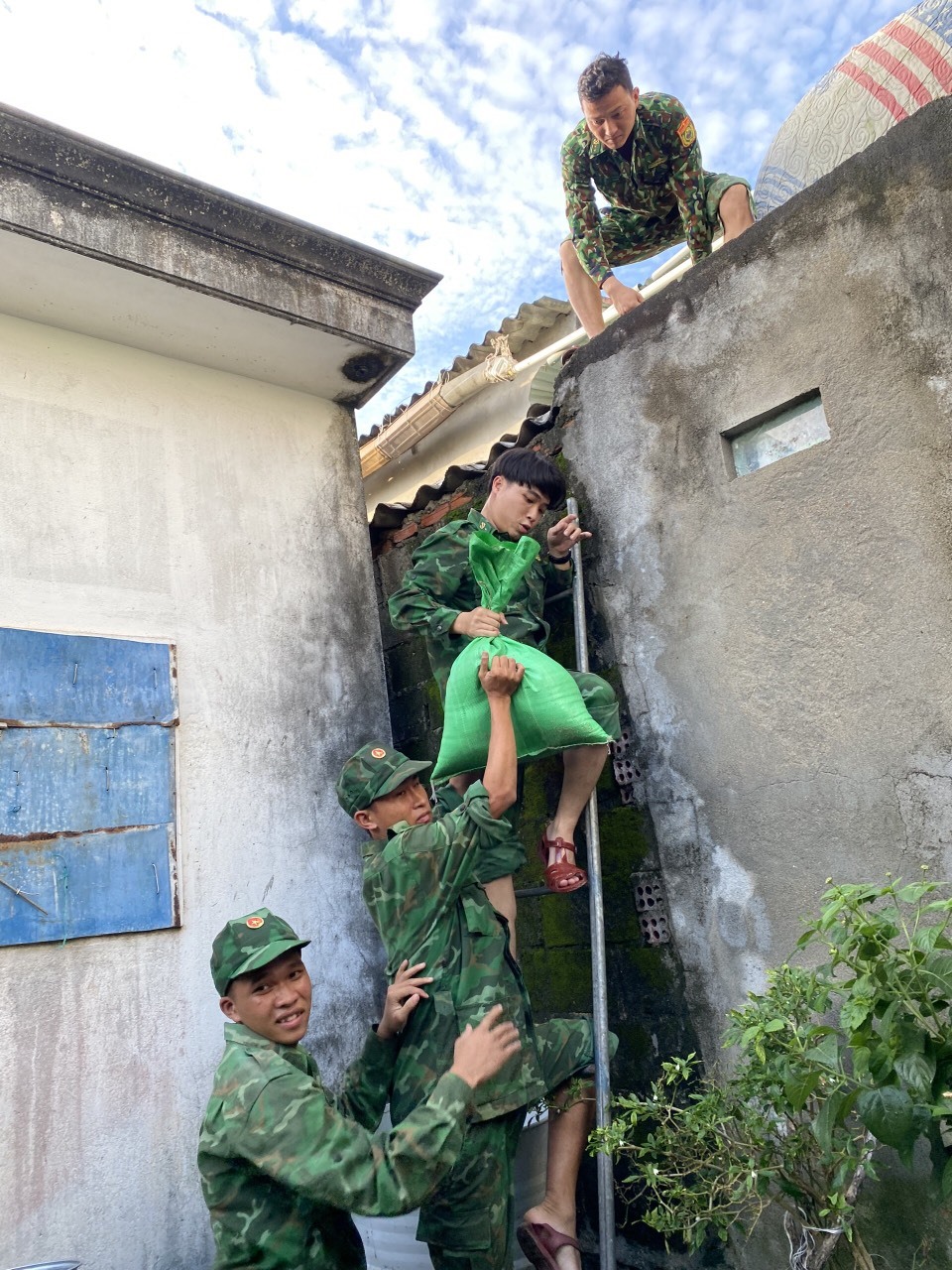 Bộ đội giúp dân Quảng Ngãi chằng chống nhà cửa. Anh: TS