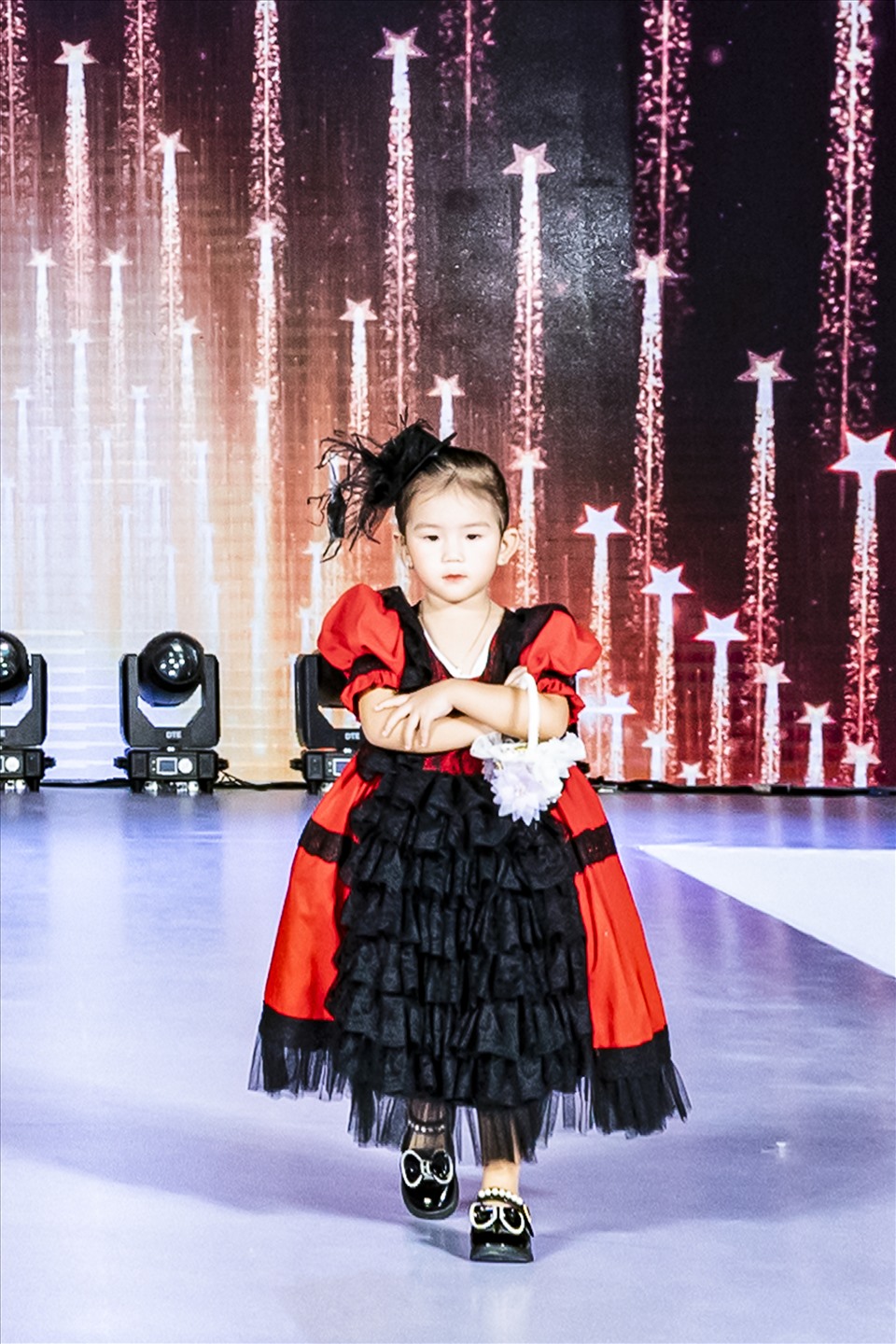 Dưới hàng ghế khán giả, ca - nhạc sĩ Khánh Đơn và bà xã Huỳnh Như hào hứng xem con gái Đồng Đồng của mình trình diễn thời trang trên sân khấu. Trong lần này, cô bé tiếp tục khuấy đảo sàn diễn với sự đáng yêu trong chiếc váy đỏ nổi bật.