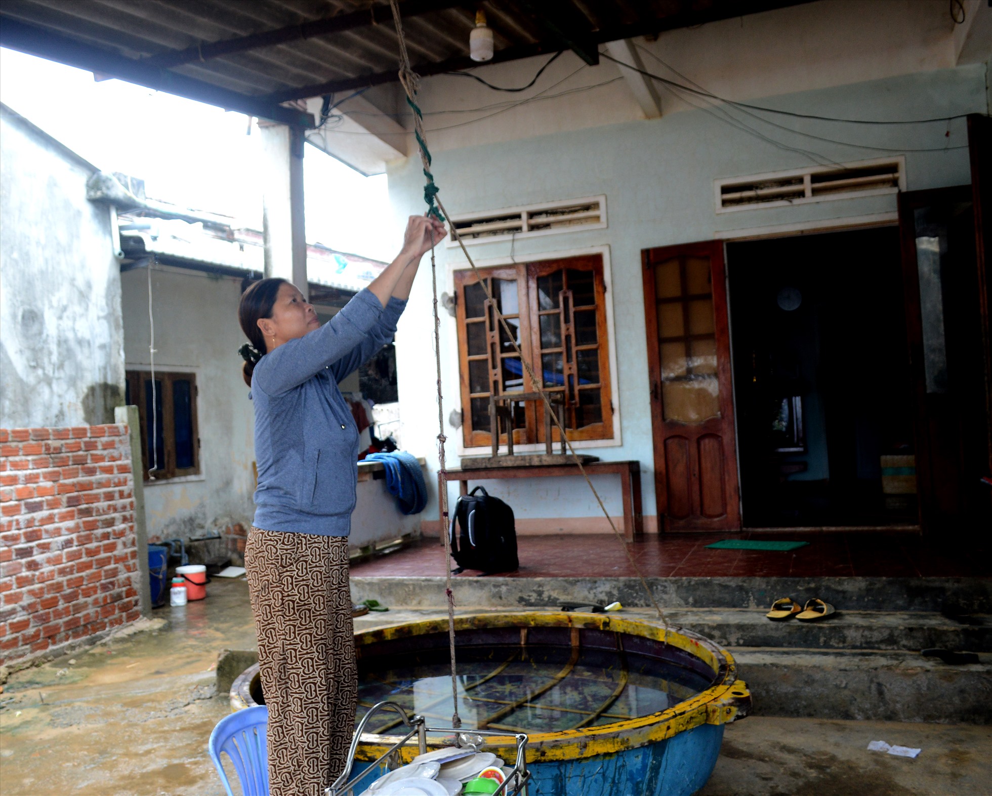 Chị Trịnh Thị Hiền (49 tuổi) ở thôn Phước Thiện, xã Bình Hải, huyện Bình Sơn (Quảng Ngãi chằng chống nhà cửa trước bão Noru. Năm 2009, chồng và người thân của chị mất trên biển vì gặp bão lớn.