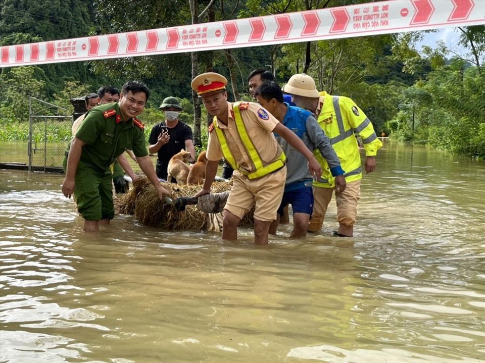 Công an huyện Anh Sơn giúp người dân khắc phục hậu quả mưa bão, vận chuyển đồ đạc và lương thực đến nơi an toàn. Ảnh: Quỳnh Trang