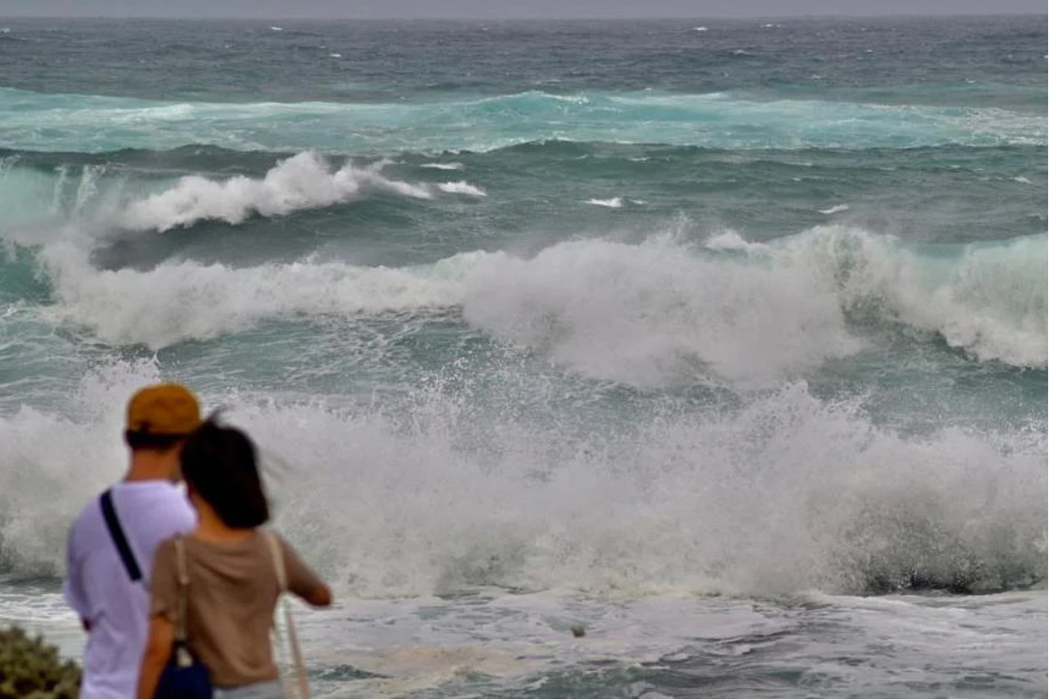 Du khách ngắm sóng biển ngoài khơi Đài Loan (Trung Quốc) khi bão Hinnamnor áp sát ngày 3.9. Ảnh: AFP