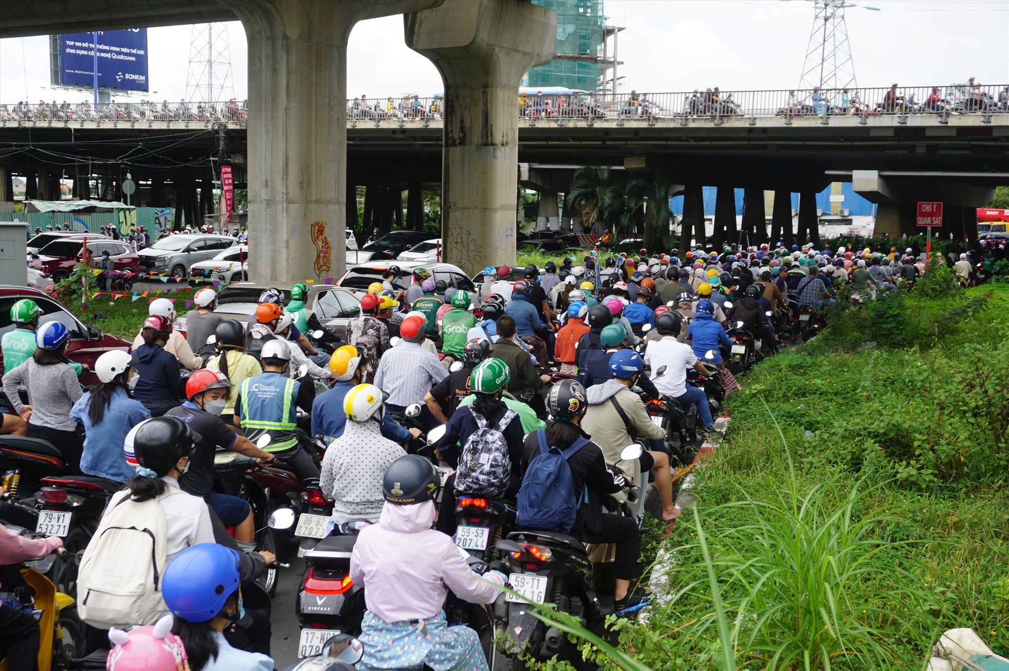 Hướng dưới dạ cầu Sài Gòn vào đường nội bộ khu đô thị Vinhomes Central park để ra đường Nguyễn Hữu Cảnh cũng đông nghịt xe, người dân đi lại vô cùng khó khăn, khổ sở.