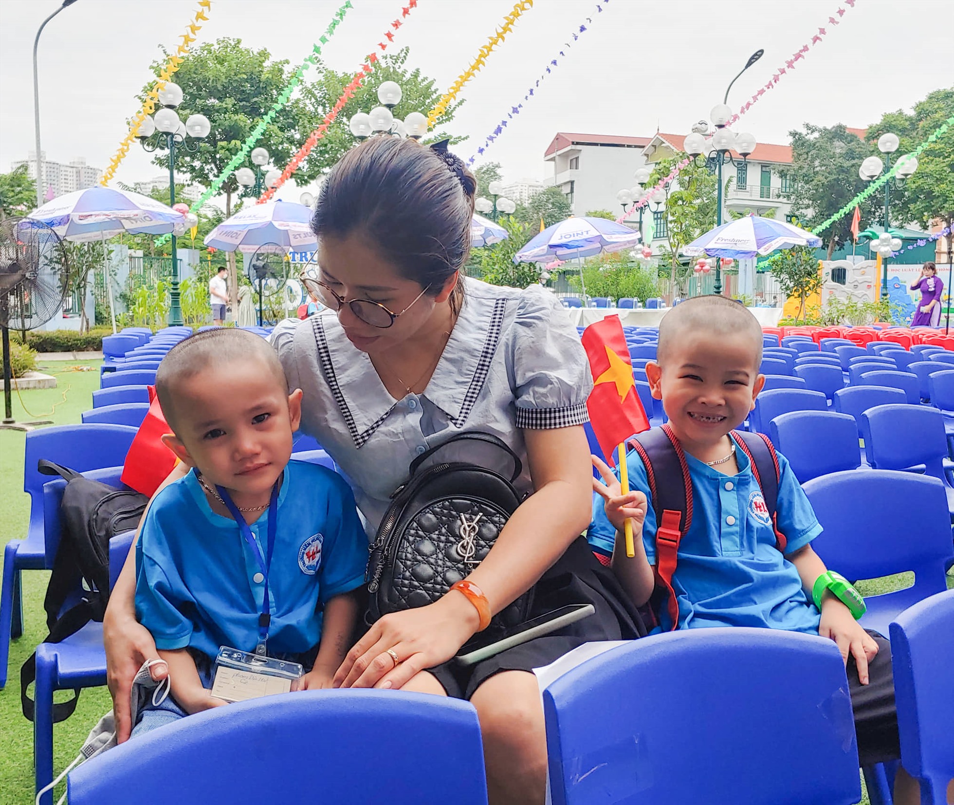 Chị Vũ Thị Trinh (Hoàng Liệt, Hoàng Mai) cùng hai con dự lễ khai giảng tại ngôi trường vừa tổ chức lễ bốc thăm để giành suất học.