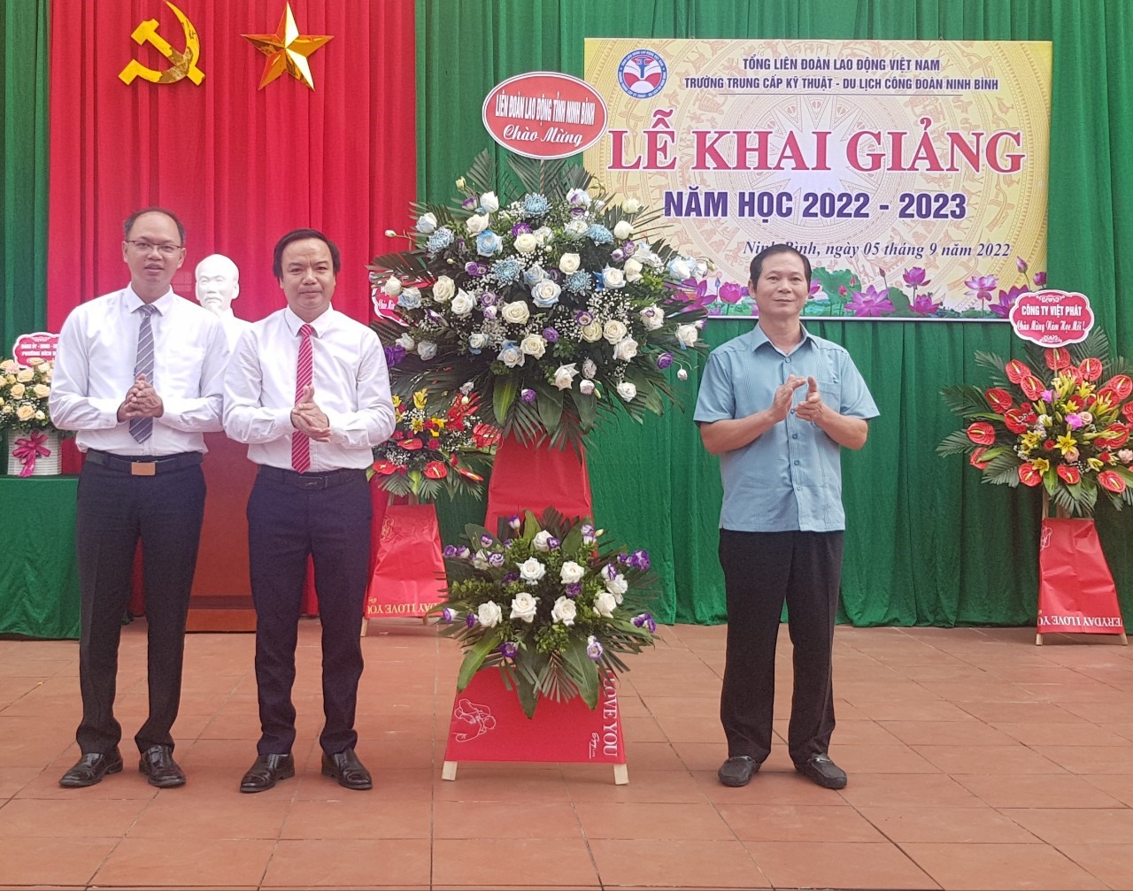 Ông Trần Kim Long, Phó chủ tịch LĐLĐ tỉnh Ninh Bình tặng hoa chúc mừng nhà trường. Ảnh: NT