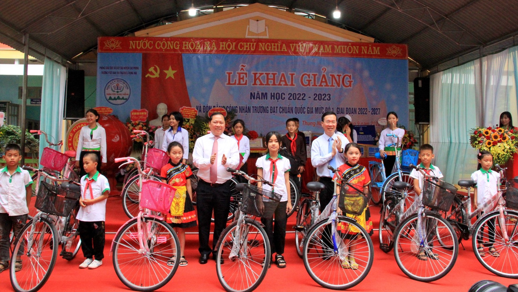 Đồng chí Võ Văn Thưởng (phải) tặng xe đạp cho các em học sinh nghèo vượt khó.