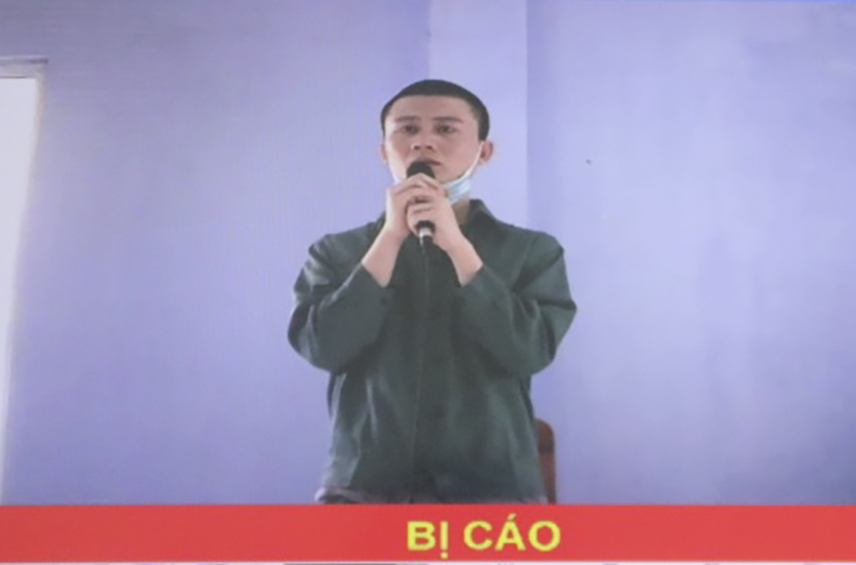 Hình ảnh bị cáo Lê Minh Trí tại trại tạm giam Công an tỉnh được truyền đến màn hình tại tòa. Ảnh: DT