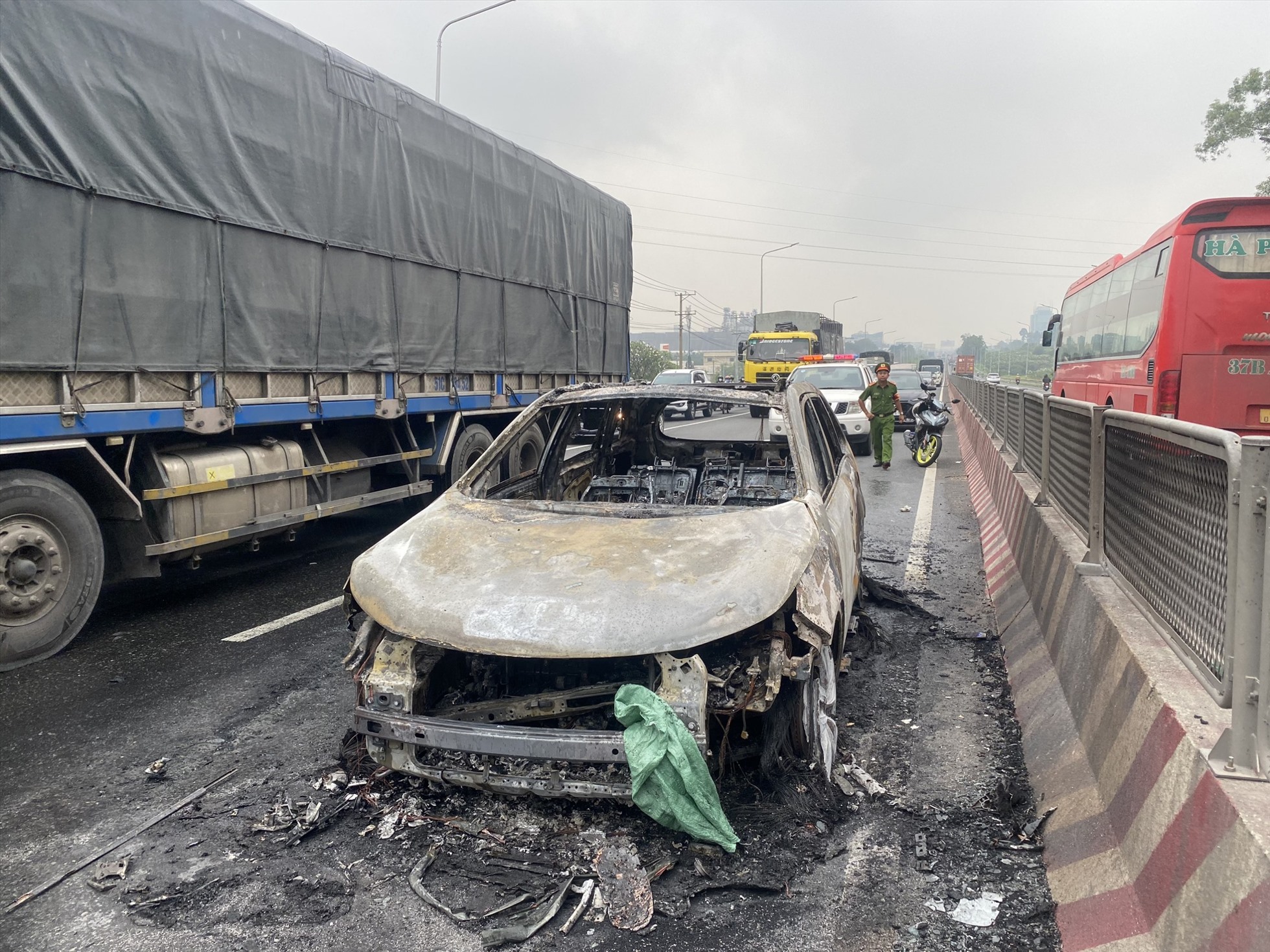 Hiện trường vụ xe ô tô đang chạy bỗng dưng bốc cháy trên quốc lộ 1 đoạn qua TP.Biên Hoà, Đồng Nai. Ảnh: CTV