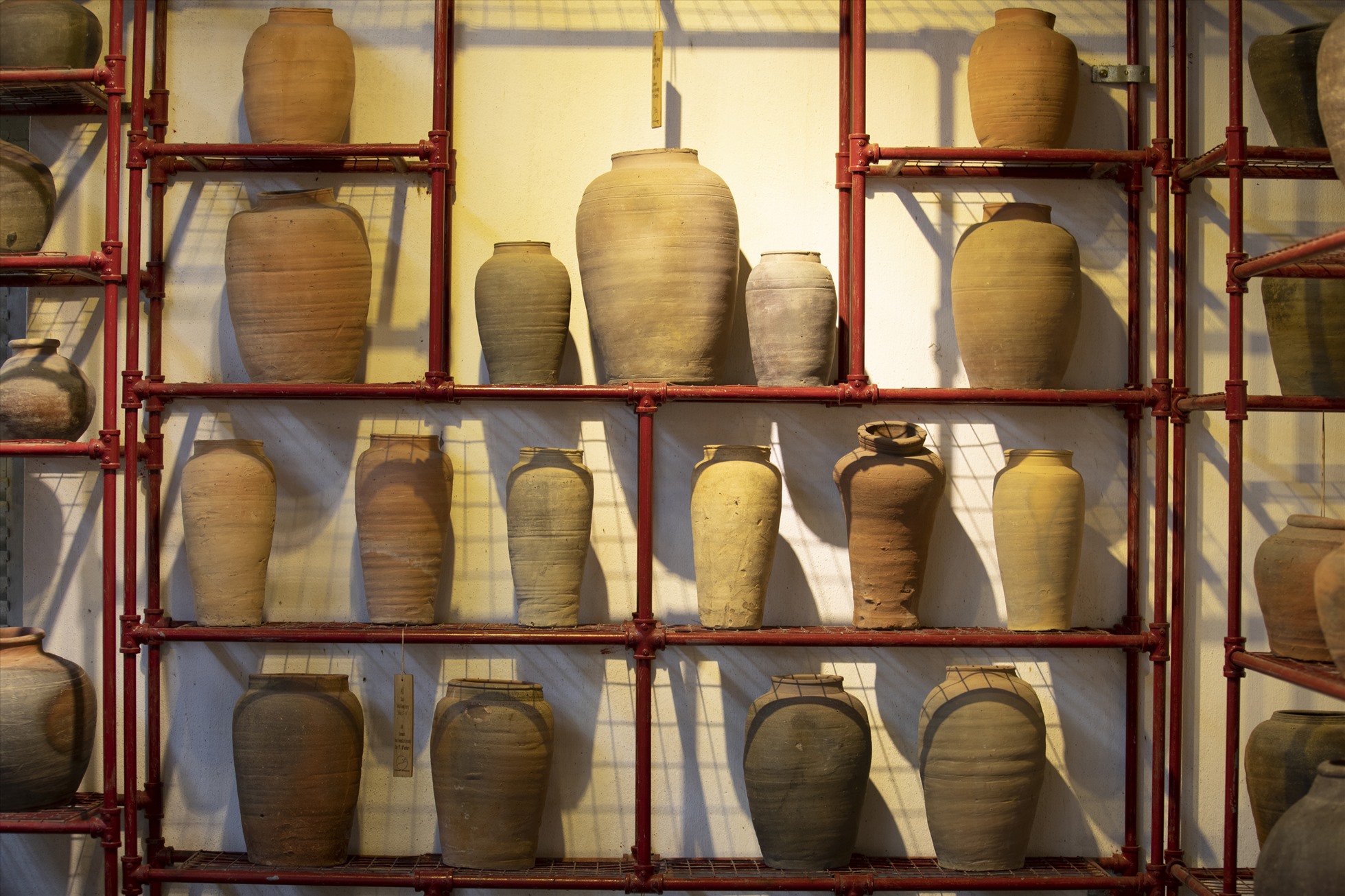 Những chiếc bình gốm cổ được bài trí trên giá, theo các thời kỳ lịch sử.