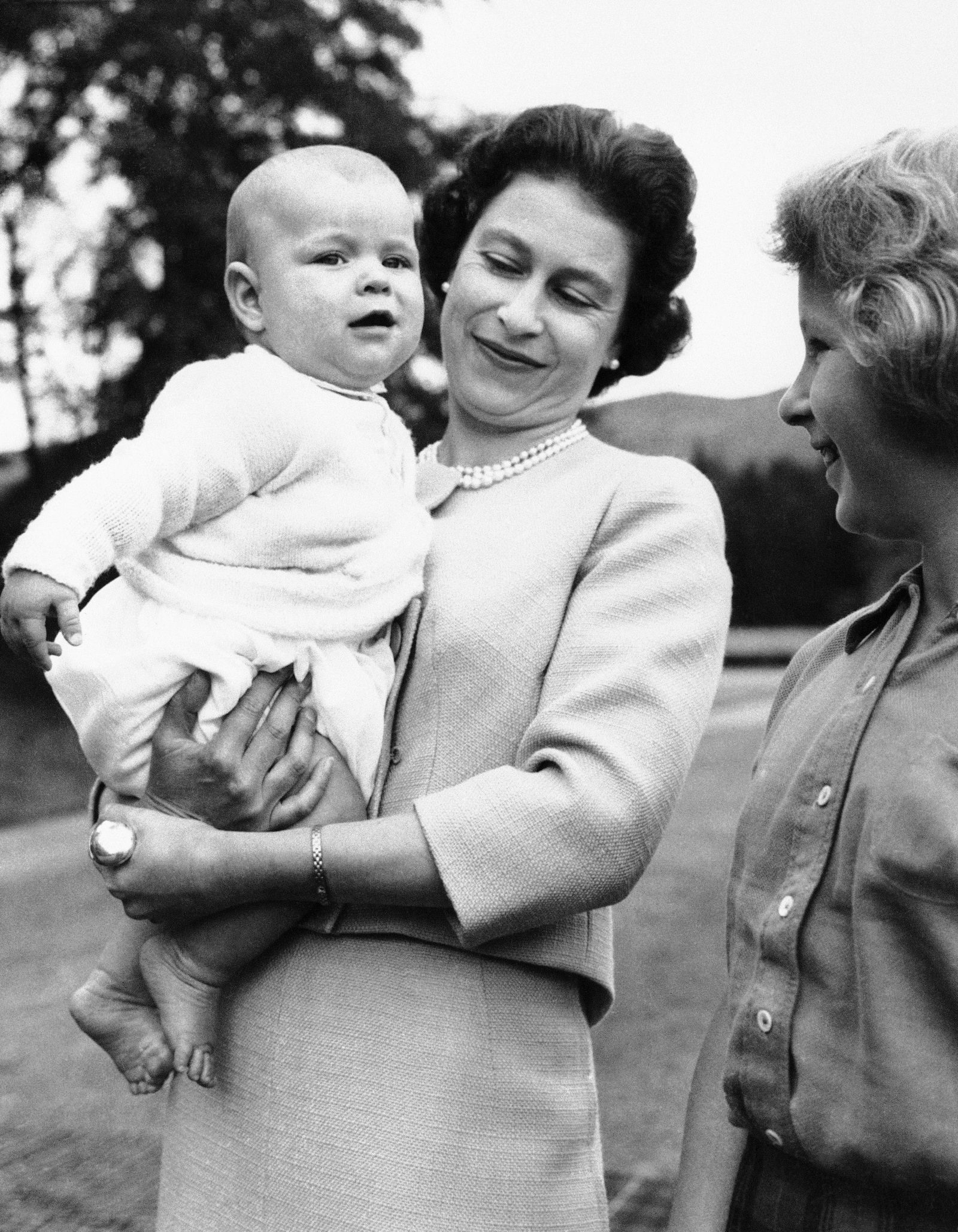 Nữ hoàng bế con trai là Hoàng tử Andrew ở Lâu đài Balmoral của Scotland vào tháng 9 năm 1960. Nữ hoàng có bốn người con. Ảnh: AP