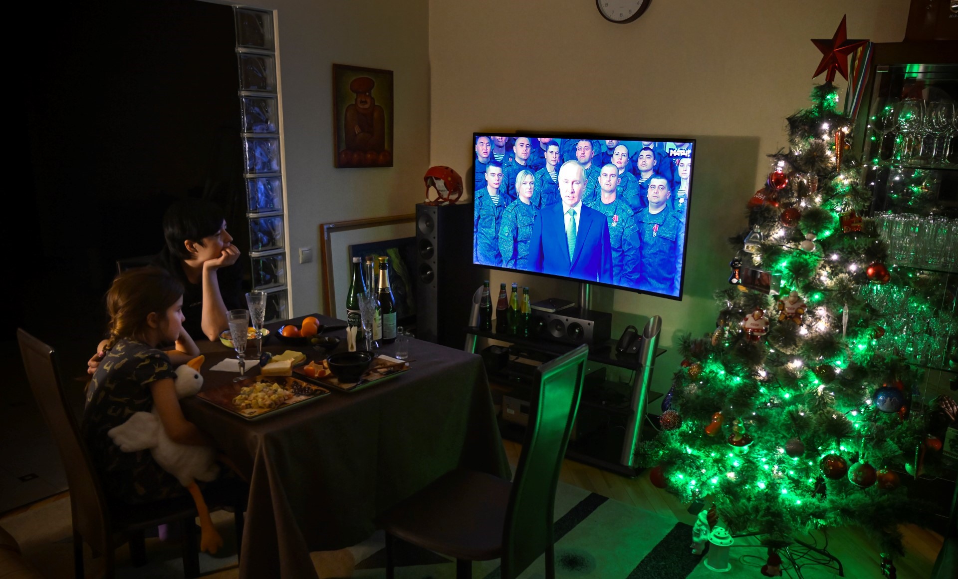 Một gia đình ở Mátxcơ xem tivi Tổng thống Putin phát biểu chào mừng năm mới ngày 31.12.2022. Ảnh: AFP