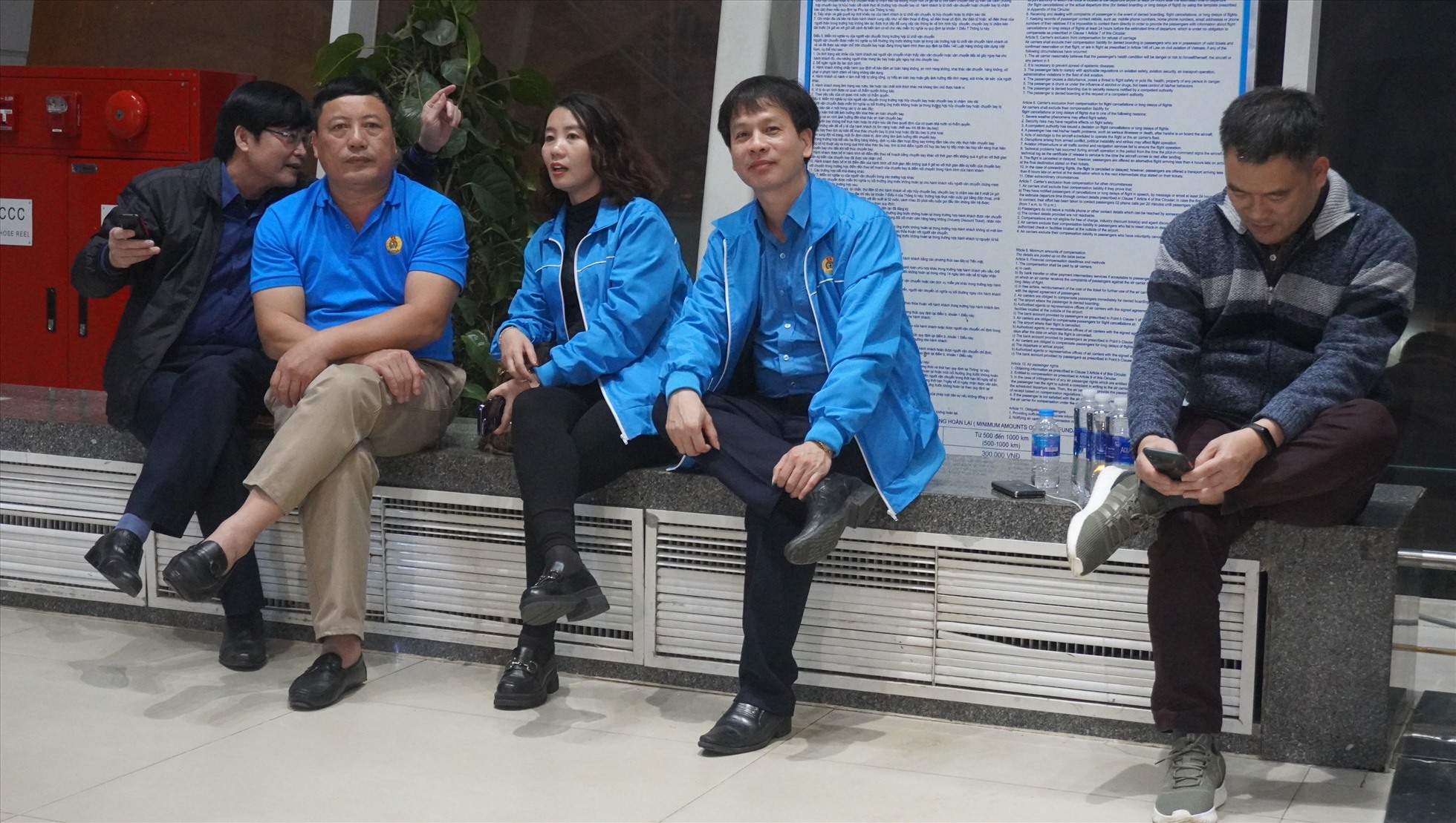 Cán bộ LĐLĐ tỉnh Thanh Hóa ngồi tại sân bay trong nhiều giờ để chờ đón công nhân. Ảnh: Quách Du