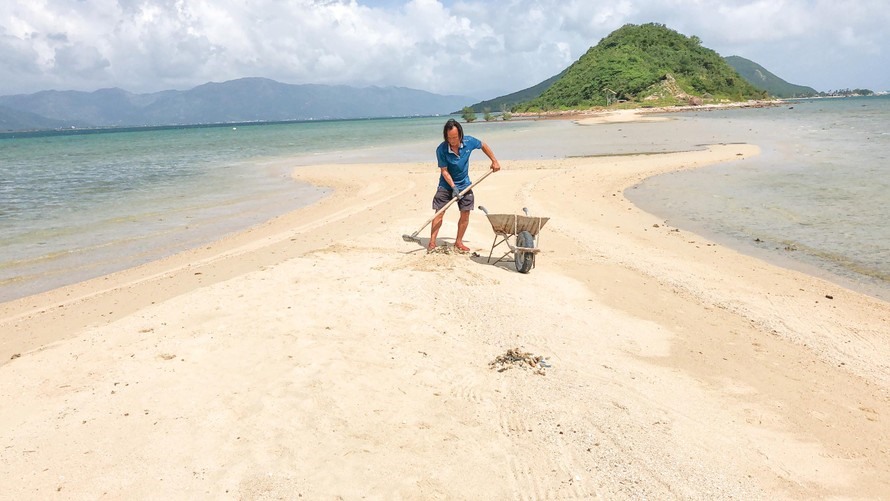 Anh Trịnh Minh Đại Anh hằng ngày vẫn nhặt rác trên đảo để bảo vệ môi trường. Ảnh: Lữ Hồ
