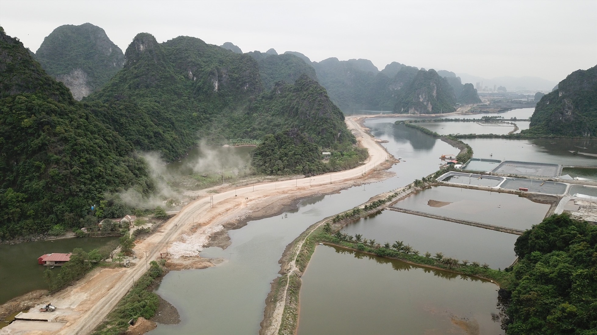 Đường ven biển Hạ Long – Cẩm Phả, chỉ dài khoảng 18,6km, nhưng hướng tuyến đi qua hầu hết đều là núi đá vôi, đầm, hồ ven biển. Cho đến nhiều tháng sau khi khởi công xây dựng, công trình đường hầm xuyên núi dài 235m vẫn chưa có trong thiết kế. Ảnh: Nguyễn Hùng