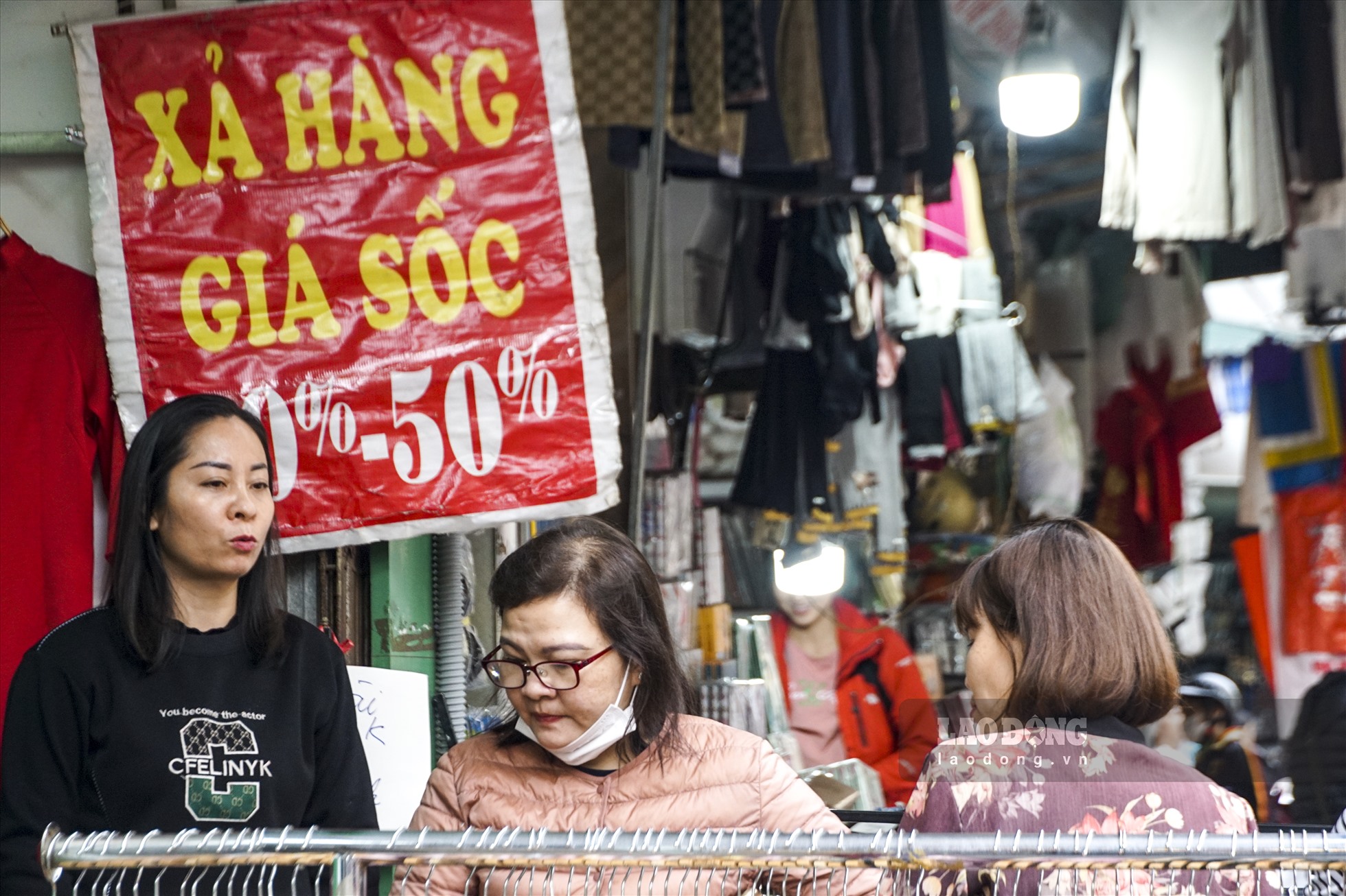 Trên phố Hàng Ngang, Hàng Đào, nhiều cửa hàng bán quần áo treo biểm giảm giá để thu hút khách hàng.