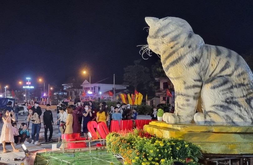 Chưa đến Tết, nhưng tượng linh vật mèo đặt ở Quảng trường trung tâm huyện Triệu Phong đã thu hút người dân đến chụp ảnh làm kỷ niệm. Ảnh: Anh Xuân.