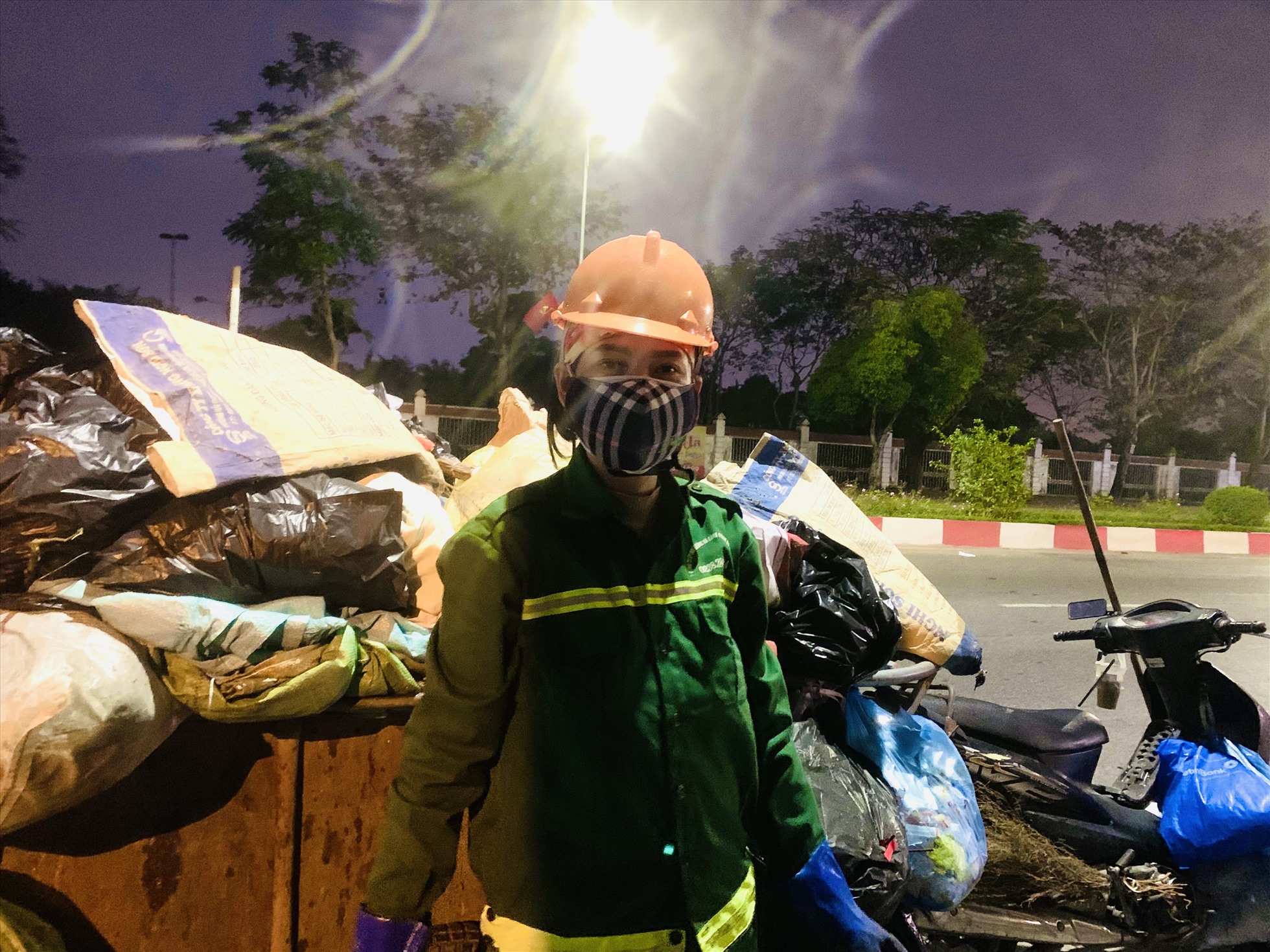 Chi Trần Thị Kim Dung cho biết, công việc làm sạch đường bắt đầu từ 14h đến tận 22 - 23 giờ mỗi ngày. Những ngày cận tết, lượng rác nhiều nên từ 13h chị bắt đầu nổ xe kèo đi thu gom, tập kết rác thải trên tuyến đường được giao không kể nắng hay mưa. Ảnh: Quỳnh Trang