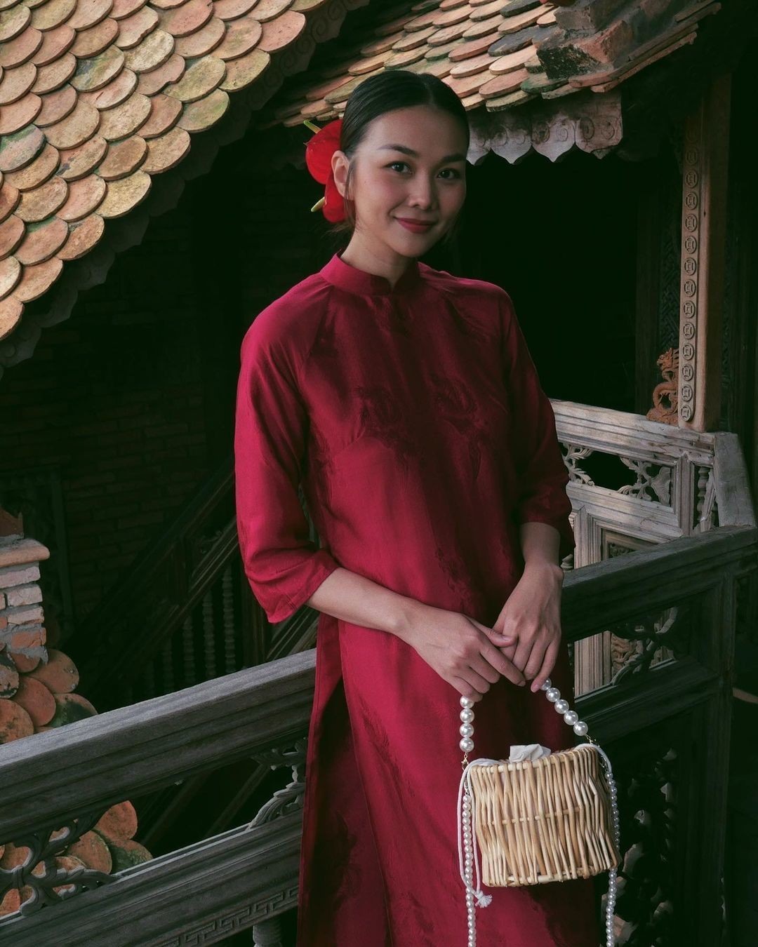 Thanh Hằng chọn áo dài cổ điển, cài hoa hồng môn trên tóc, phối túi cói.