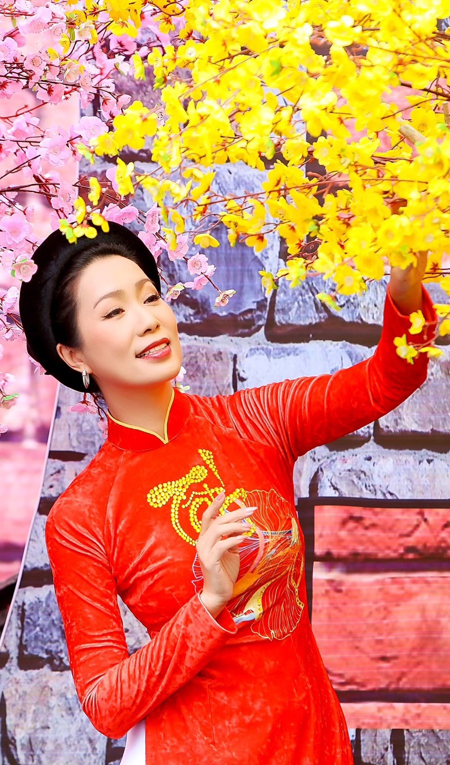 NSƯT Trịnh Kim Chi chọn những chiếc đầm hoa rực rỡ, hòa vào bối cảnh kết hợp giữa truyền thống và hiện đại, đúng với không khí của ngày Tết.