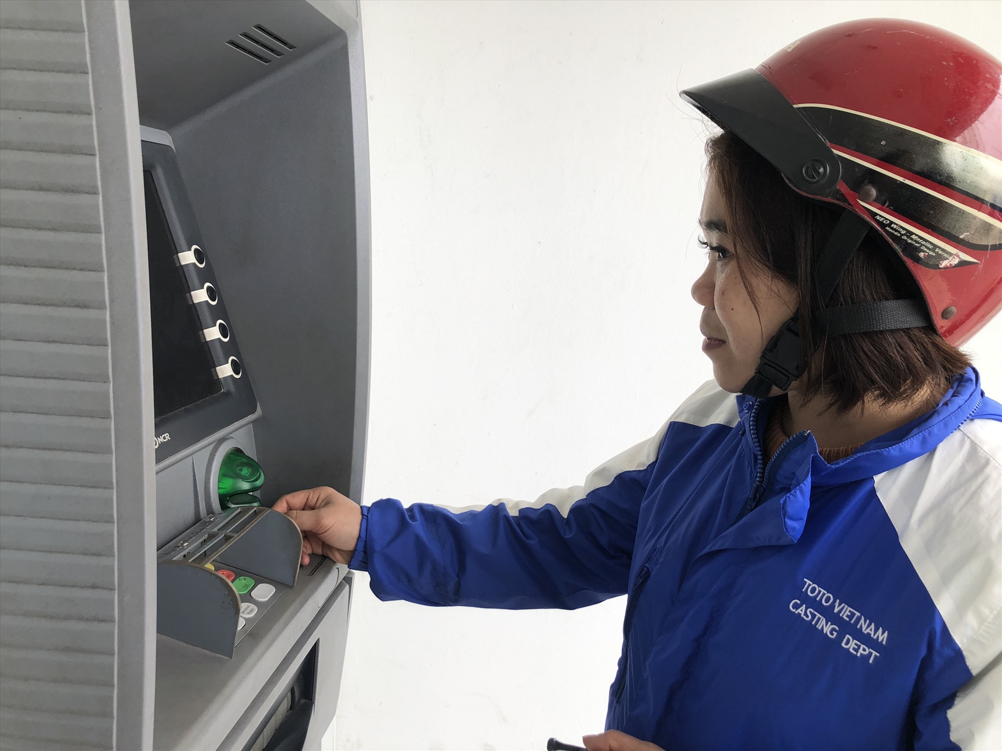 Chị Đỗ Thị Nhương rút tiền từ cây ATM trước khi cả gia đình về quê ăn Tết. Ảnh: Bảo Hân