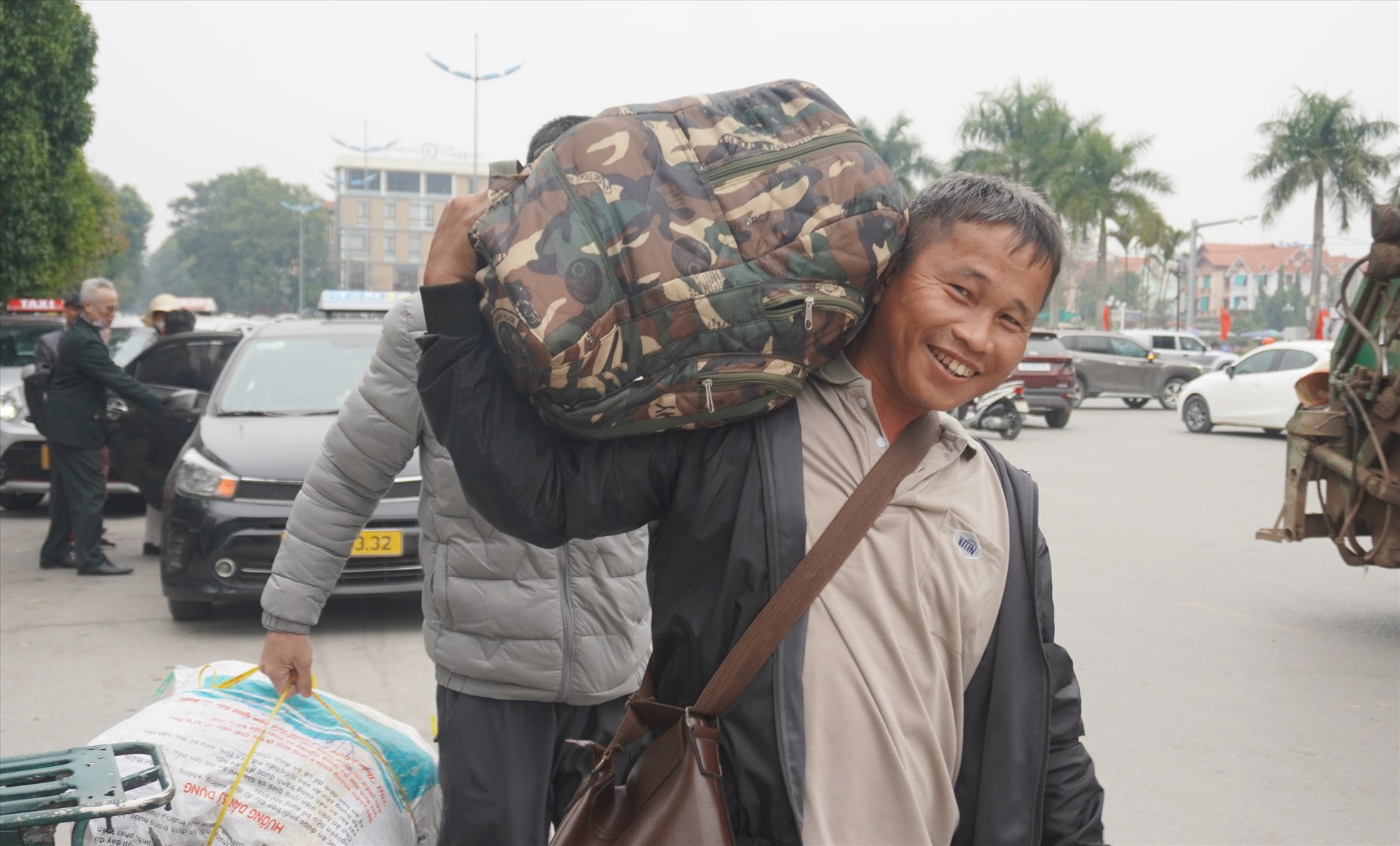 Anh Lê Quốc Xuân (làm việc ở tỉnh Ninh Thuận) sau khi xuống ga đã nhanh chóng mang vác đồ đạc, ra đón xe taxi về quê (ở huyện Hoằng Hóa, Thanh Hóa) đón Tết. Ảnh: Quách Du