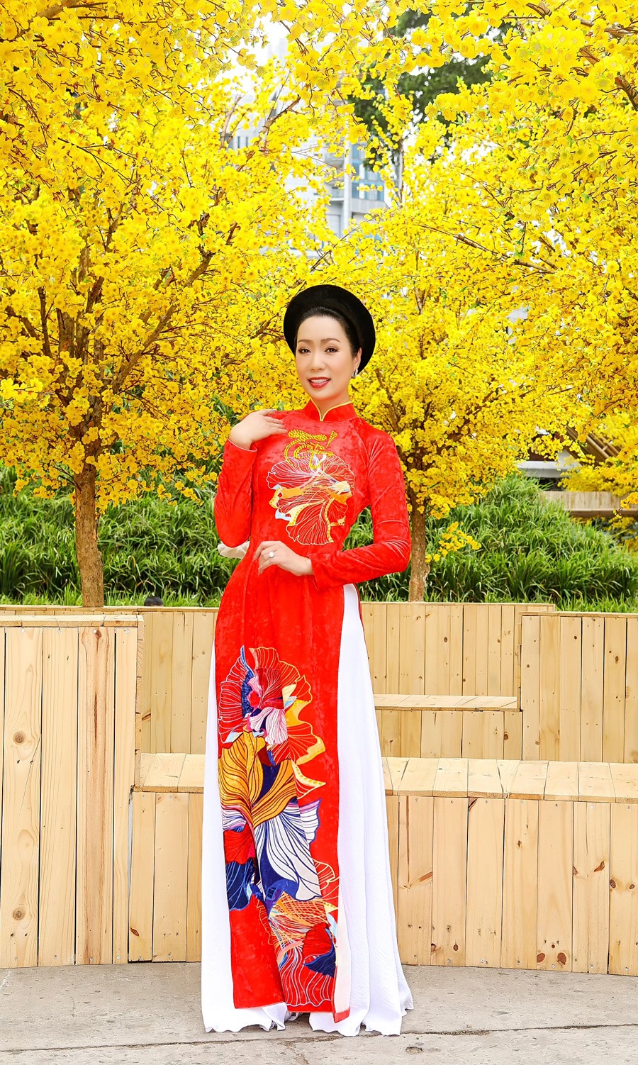 NSƯT Trịnh Kim Chi chọn những chiếc đầm hoa rực rỡ, hòa vào bối cảnh kết hợp giữa truyền thống và hiện đại, đúng với không khí của ngày Tết.