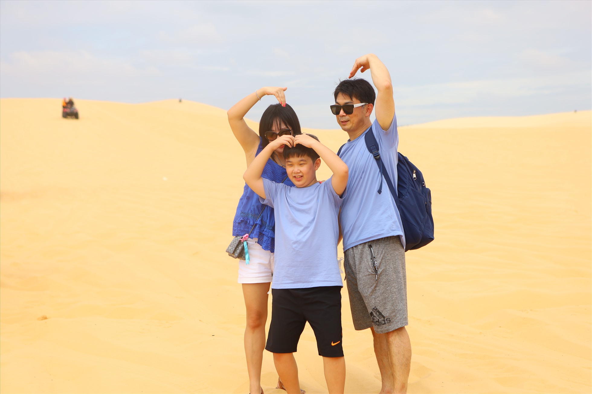 Gia đình du khách quốc tế lưu giữ khoảnh khắc tại đồi cát ở Bàu Trắng.
