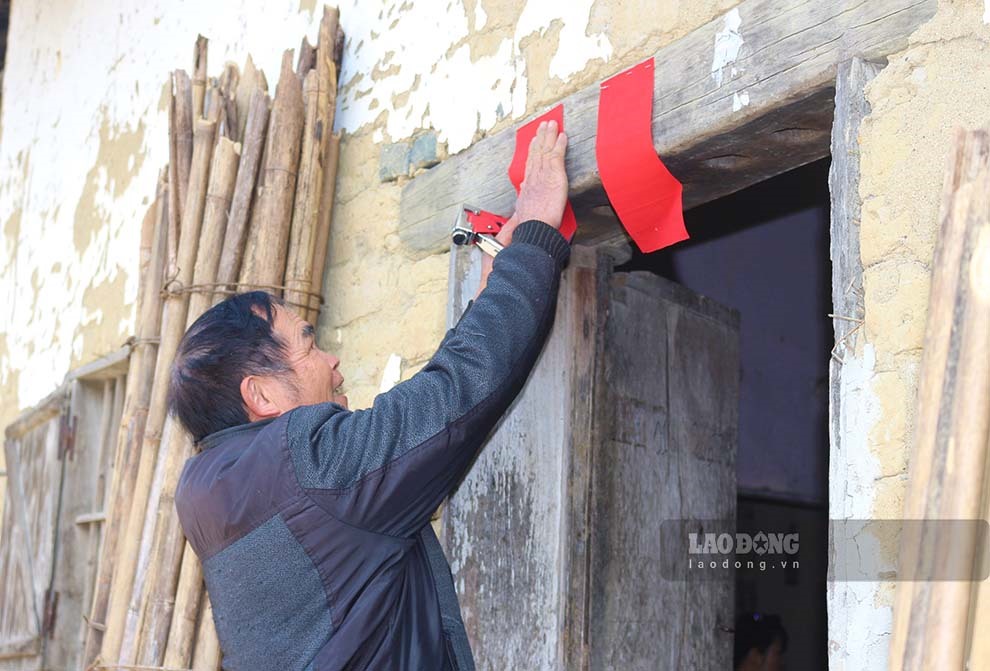 Chủ nhà dán giấy màu đỏ tượng trưng cho sự may mắn lên trước cửa nhà, bàn thờ tổ tiên. Ảnh: La Lành