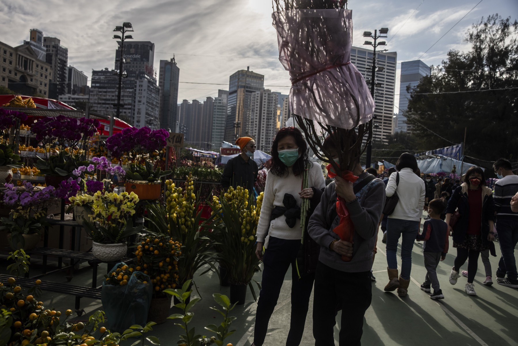 Một người phụ nữ cầm hoa mua tại chợ Tết Nguyên đán ở Hong Kong (Trung Quốc) ngày 20.1, tức ngày 29 Tết. Ảnh: AFP