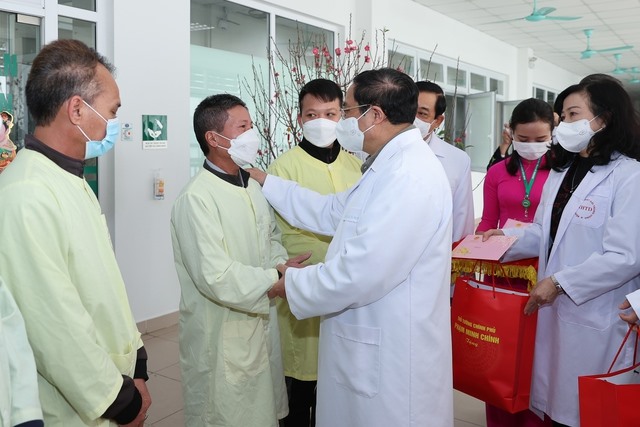 Thủ tướng Phạm Minh Chính tặng quà động viên gia đình bệnh nhân tại Bệnh viện Bệnh Nhiệt đới Trung ương. Ảnh: Nhật Bắc