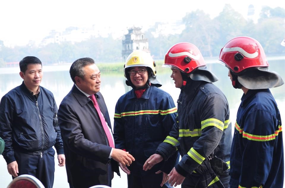 Chủ tịch UBND TP Trần Sỹ Thanh trò chuyện, động viên Cảnh sát PCCC và CNCH Hà Nội ứng trực tại trận địa pháo hoa bên hồ Gươm. Ảnh: Công Thọ