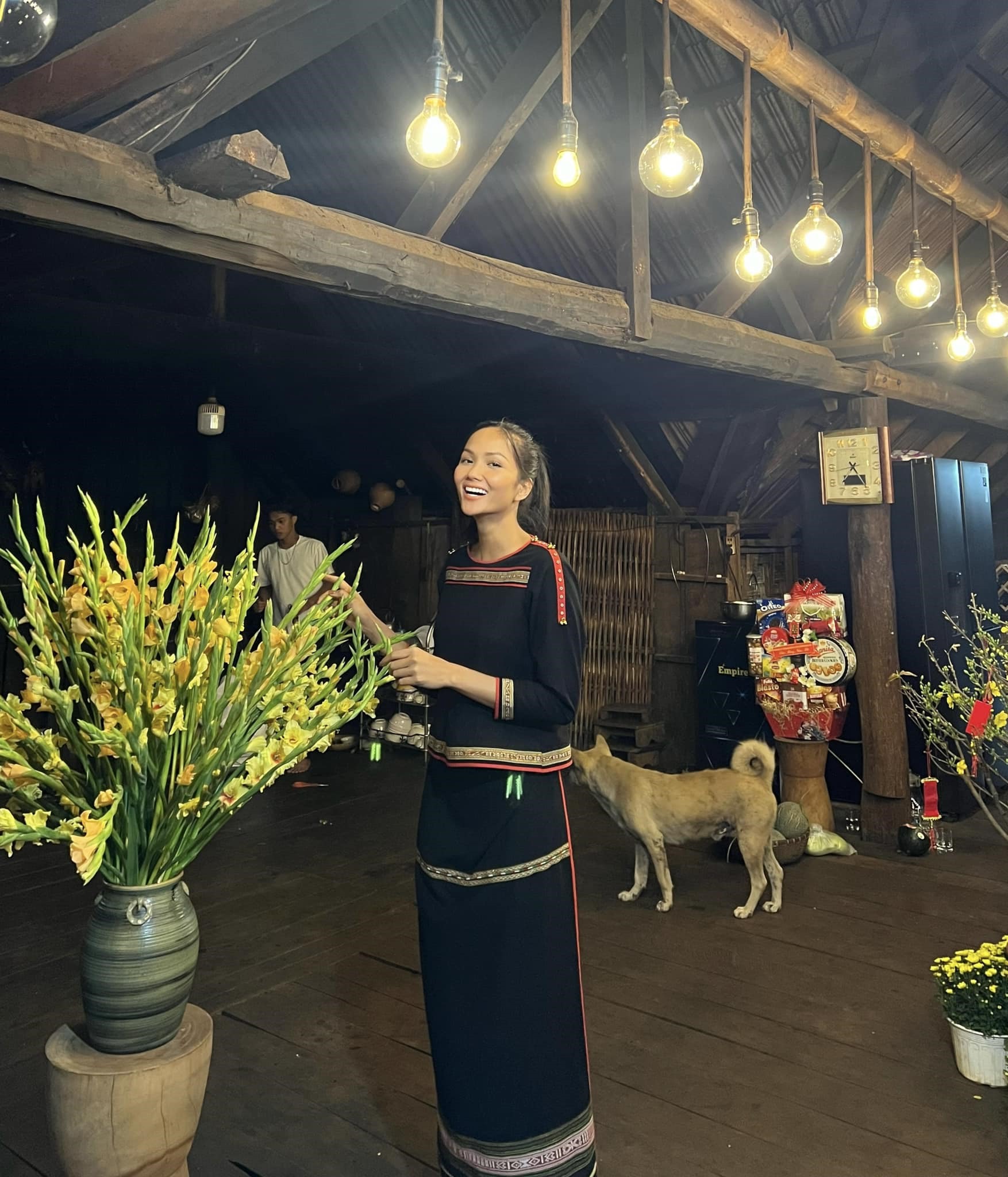 Hoa hậu H'Hen Niê về quê nhà Đắk Lắk cách đây ít ngày. Người đẹp mua nhiều loại hoa, cây kiểng như: hoa giấy, cúc mâm xôi, tắc... để trang trí. H'Hen Niê cho biết bí mật đi mua hoa, không rủ ai trong nhà nên mua không kiểm soát vì chị rất thích hoa.   Một góc nhà sàn của H'Hen Niê được trang trí với hoa lay ơn vàng. Người đẹp nói nhờ cắm bình hoa này mà biết lay ơn còn có một số tên gọi khác.