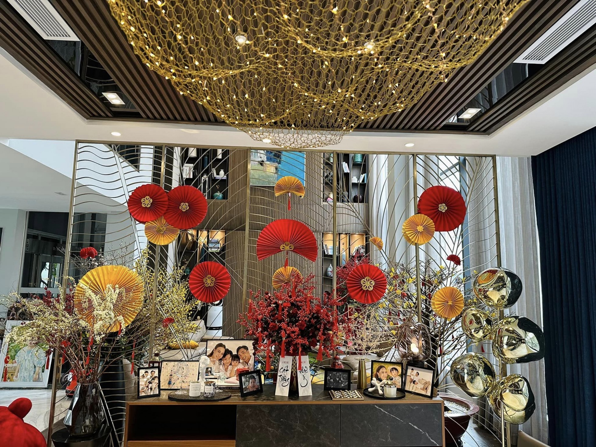 Chị cũng để nhiều ảnh của cả nhà ở không gian trang trọng nhất.    Bên cạnh mai vàng, gia chủ cũng sử dụng hoa đào để mang đến phong vị Tết miền bắc trong gia đình.  Bên ngoài nhà được trang trí bằng hoa cúc vàng cùng một số tiểu cảnh để chụp ảnh.