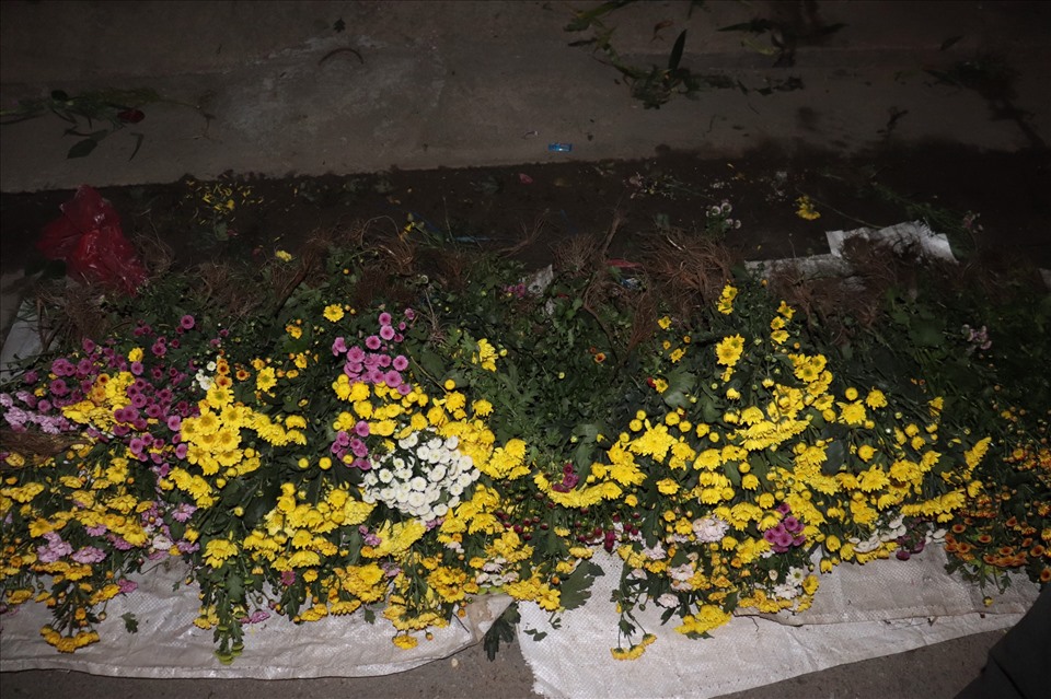Tiểu thương bỏ hoa giữa đường để về nhà đón giao thừa. Ảnh: Nguyễn Linh