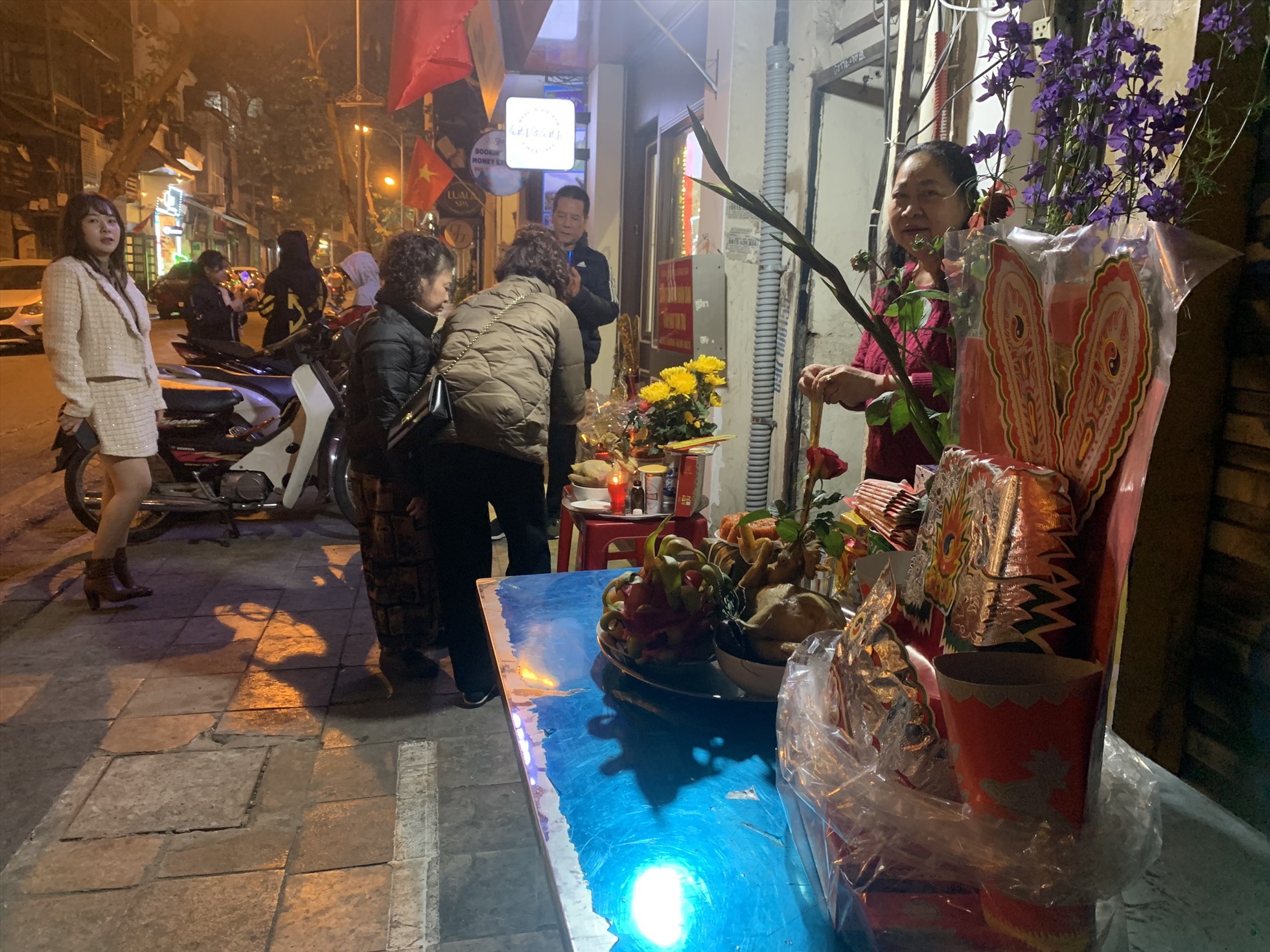 Tối 21.1 (tức 30 Tết), nhiều gia đình và hộ kinh doanh ở phố cổ Hà Nội sửa soạn mâm lễ, bày trước cửa nhà để cúng giao thừa.