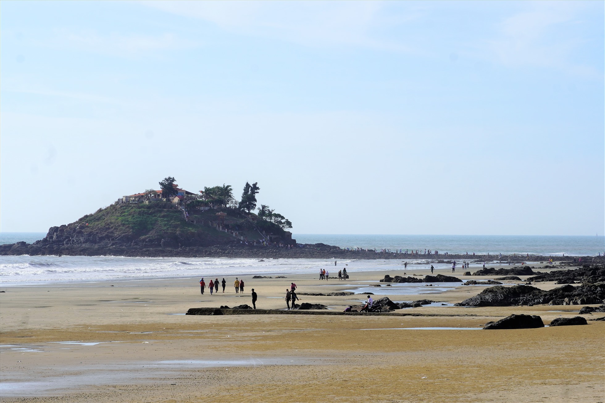 Mùng 1 Tết Nguyên đán 2023, cùng với đi lễ chùa, nhiều gia đình, du khách cũng nhân dịp nước thủy triều rút để vượt qua bãi biển đến viếng ngôi miếu trên đảo Hòn Bà cầu an. Ảnh: Thành An