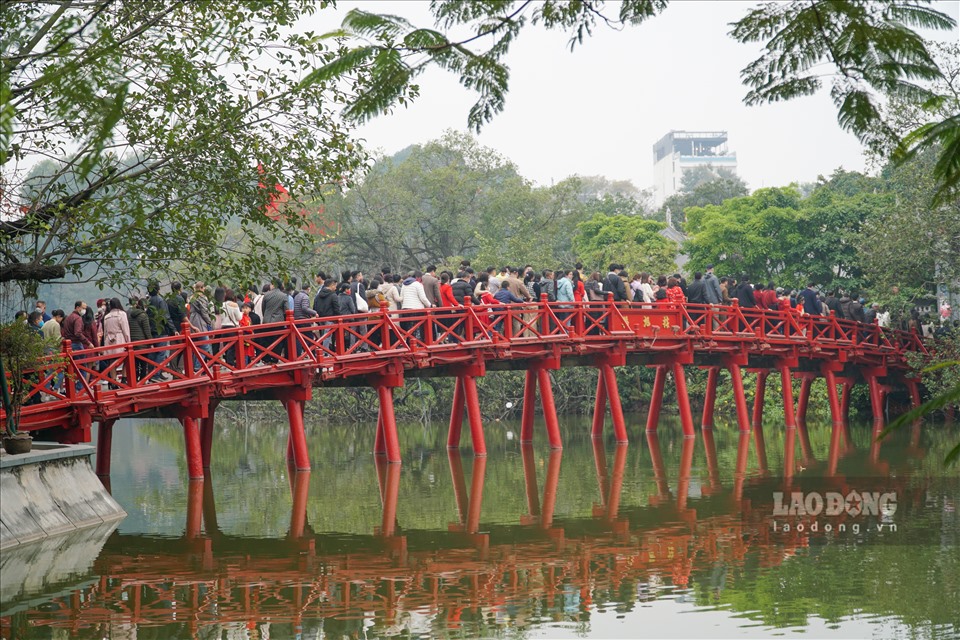 Ngày mùng 1 Tết, nhiều người dân Hà Nội chọn đi lễ chùa. Trong hình là cảnh người dân và du khách chen chân, nhích từng bước trên cầu Thê Húc dẫn vào Đền Ngọc Sơn.
