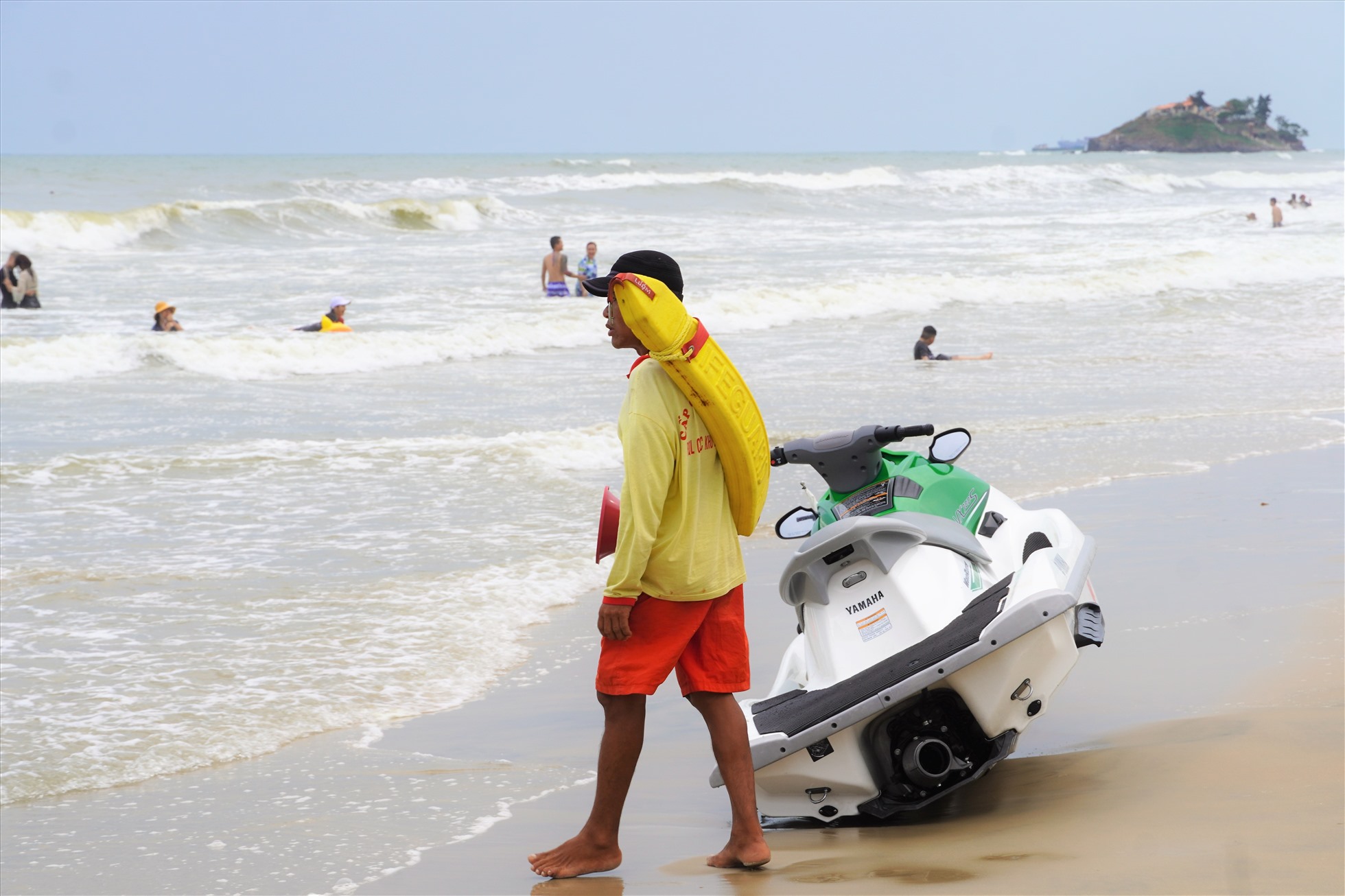 Cứu hộ viên Trần Văn Truyền tại một điểm trực ao xoáy, phải luôn theo dõi để hướng dẫn người tắm biển rời khu vực nguy hiểm. Ảnh: Thành An