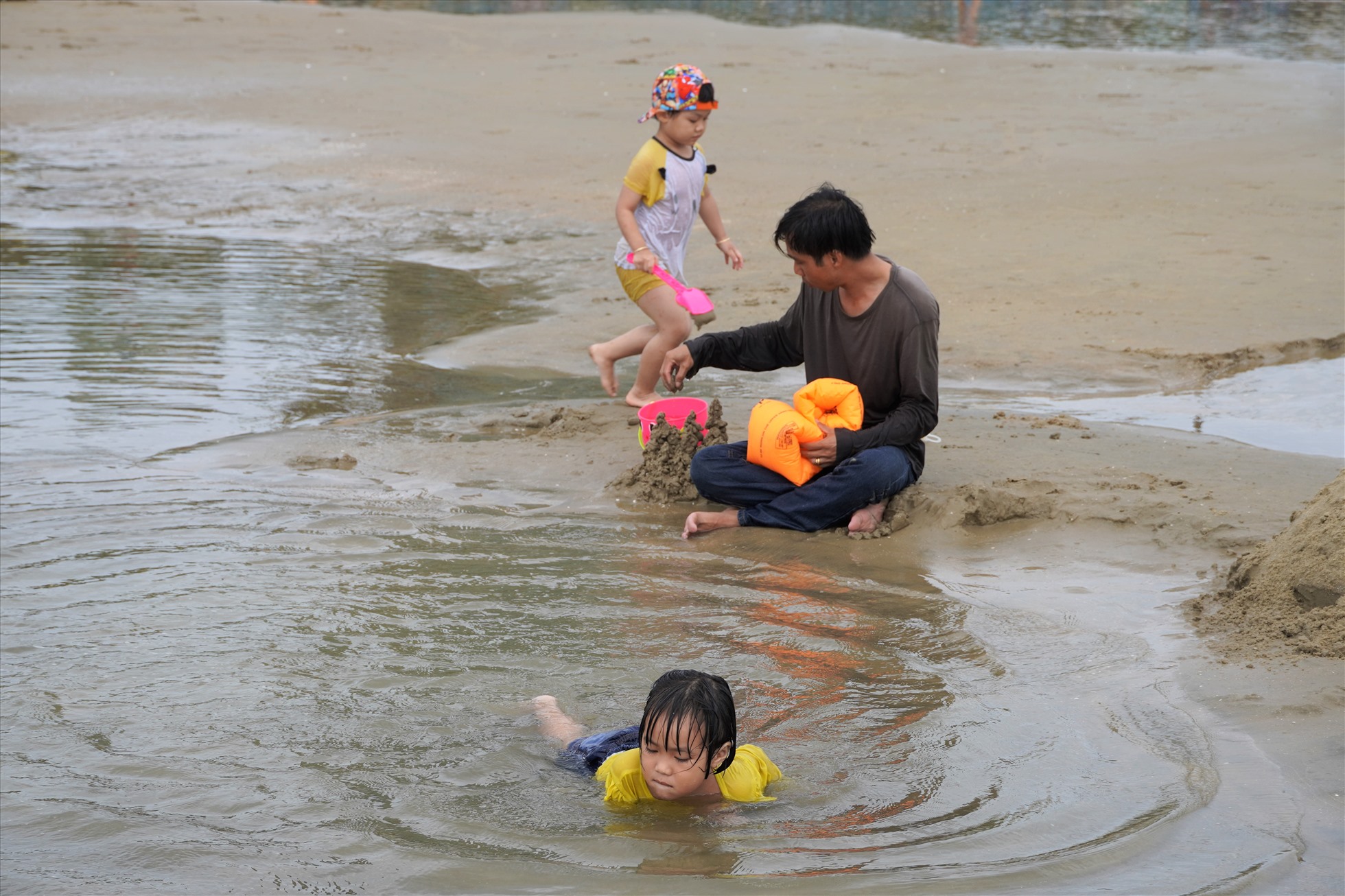 Còn những em nhỏ thì yêu thích vùng vẫy trong những hố nước trên bãi biển. Trông và chơi đùa cùng con, anh Trần Ngọc An - du khách đến từ Long An cho biết cùng nhóm gia đình đến Vũng Tàu viếng chùa và tranh thủ tắm biển, sau đó về trong ngày chứ không lưu trú. Ảnh :Thành An