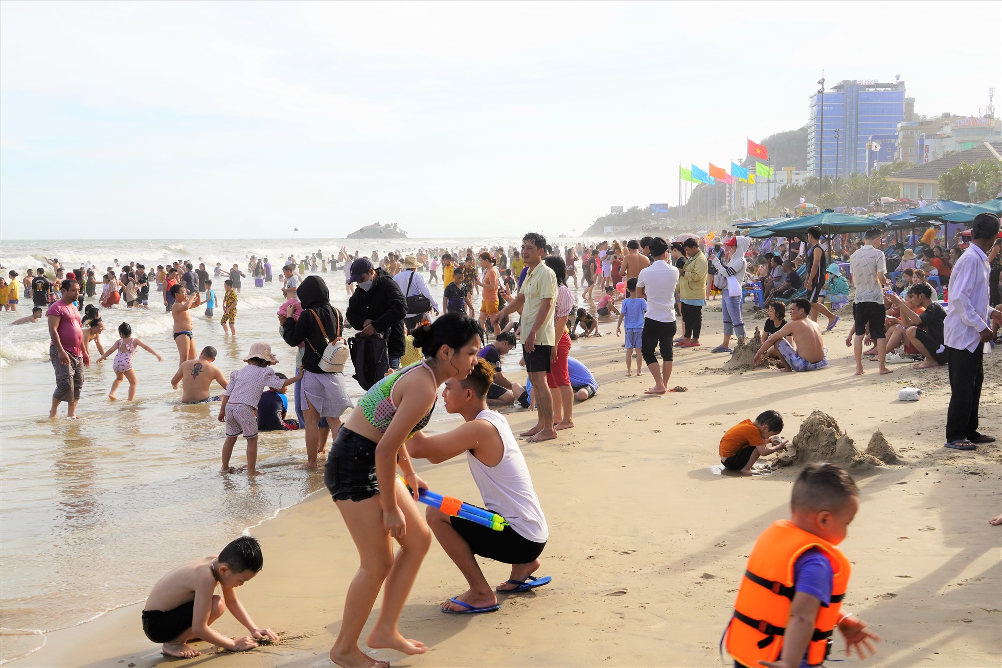 Biển đông người, nhưng thủy triều dâng khá cao làm phần bãi cát trở nên chật hẹp trước số lượng đông du khách. Ảnh: Thành An