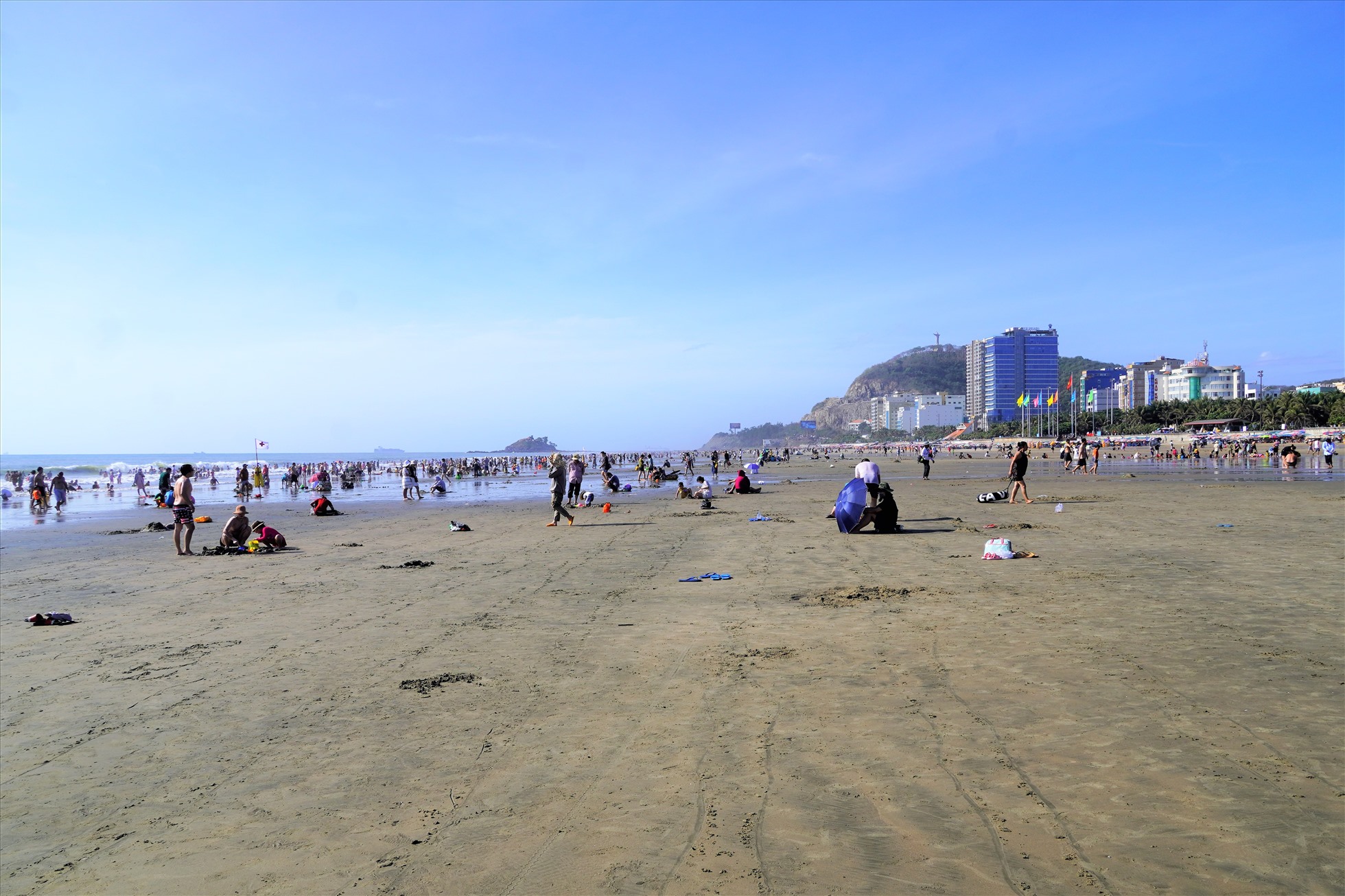 Thủy triều rút sâu tạo nên bãi cát khá rộng, nên từng nhóm du khách có không gian khá thoải mái, cách biệt, không quá chen chúc như trong chiều mùng 2 Tết. Ảnh: Thành An