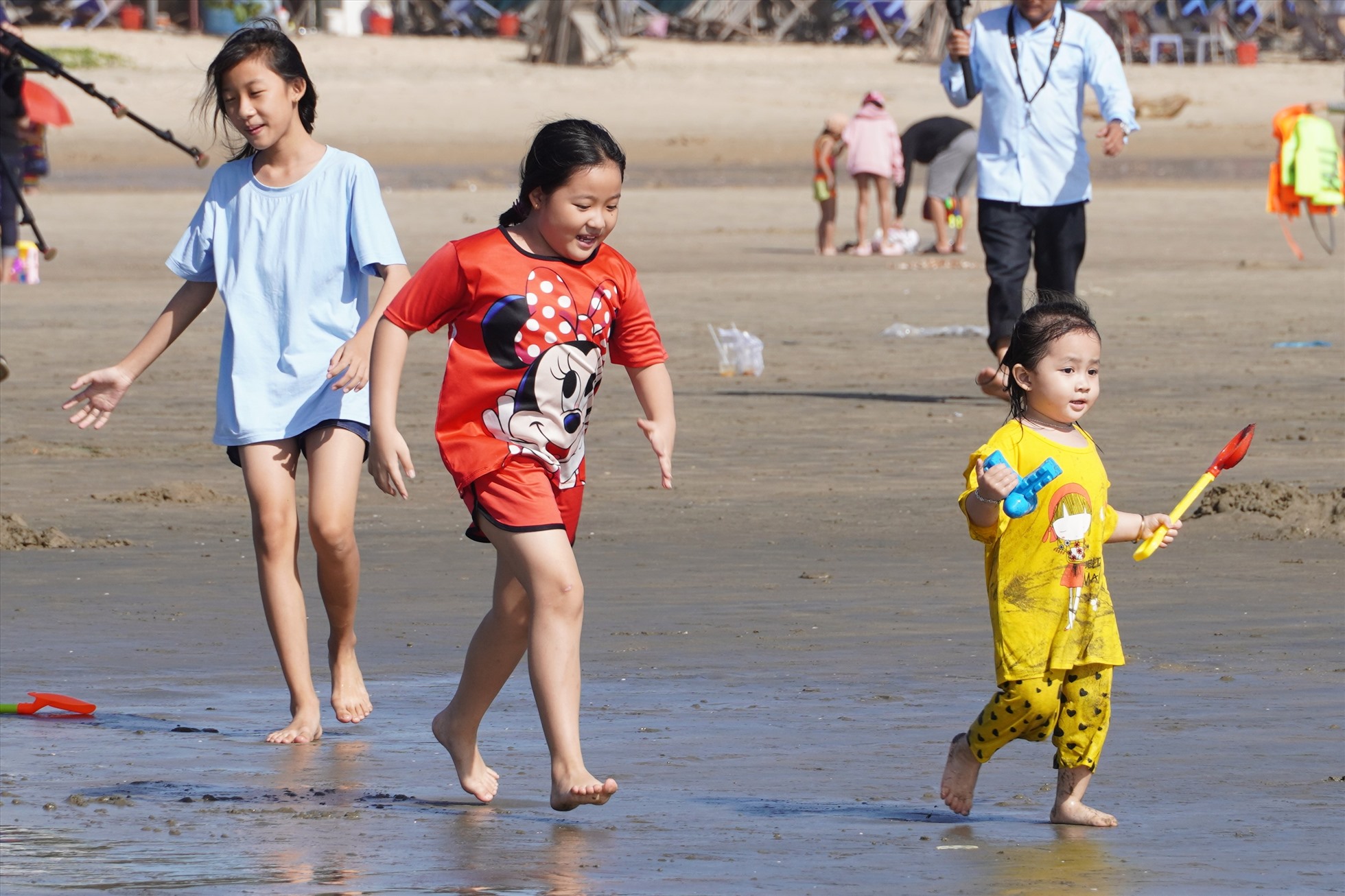 Nhiều em nhỏ phấn khởi chạy tung tăng trên bãi cát để ra gần biển. Ảnh: Thành An