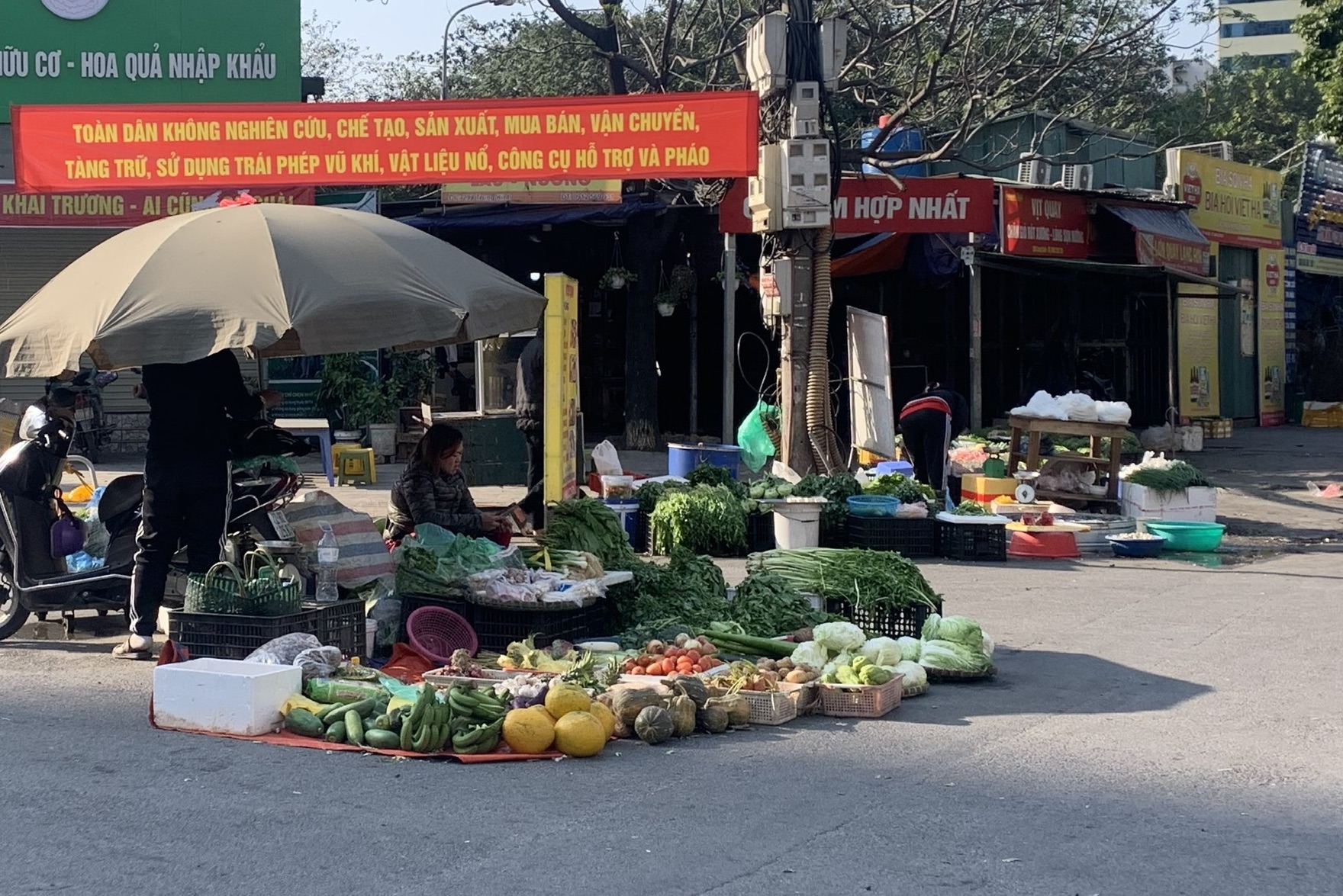 Tiểu thương bày bán hàng ngay bên ngoài cổng chợ Hợp Nhất (phường Yên Hoà, quận Cầu Giấy). Ảnh: T.Vương