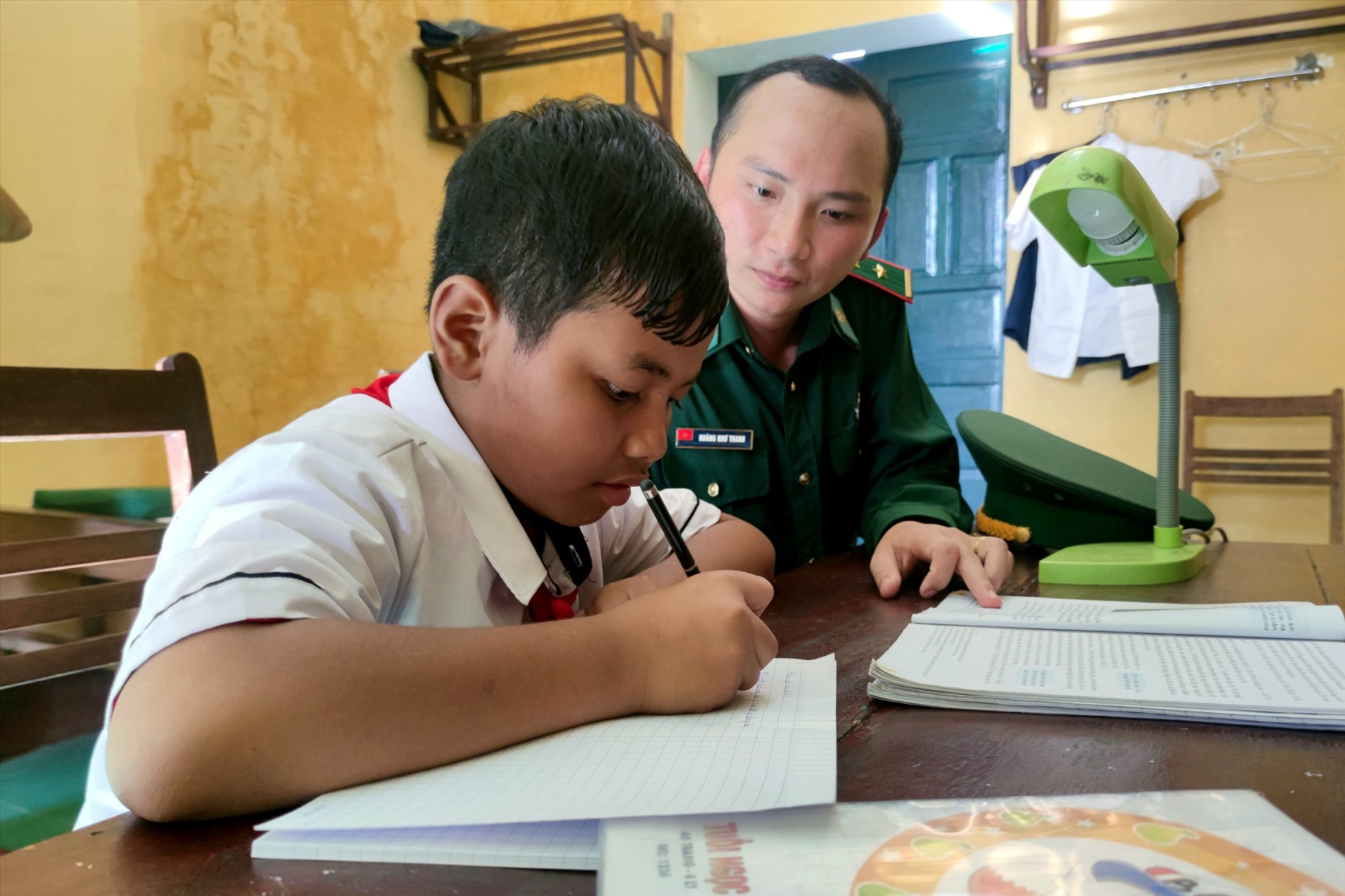 Trung uý Thanh dạy em học bài hàng ngày như một người cha, người thầy giáo. Ảnh Thanh Tuấn